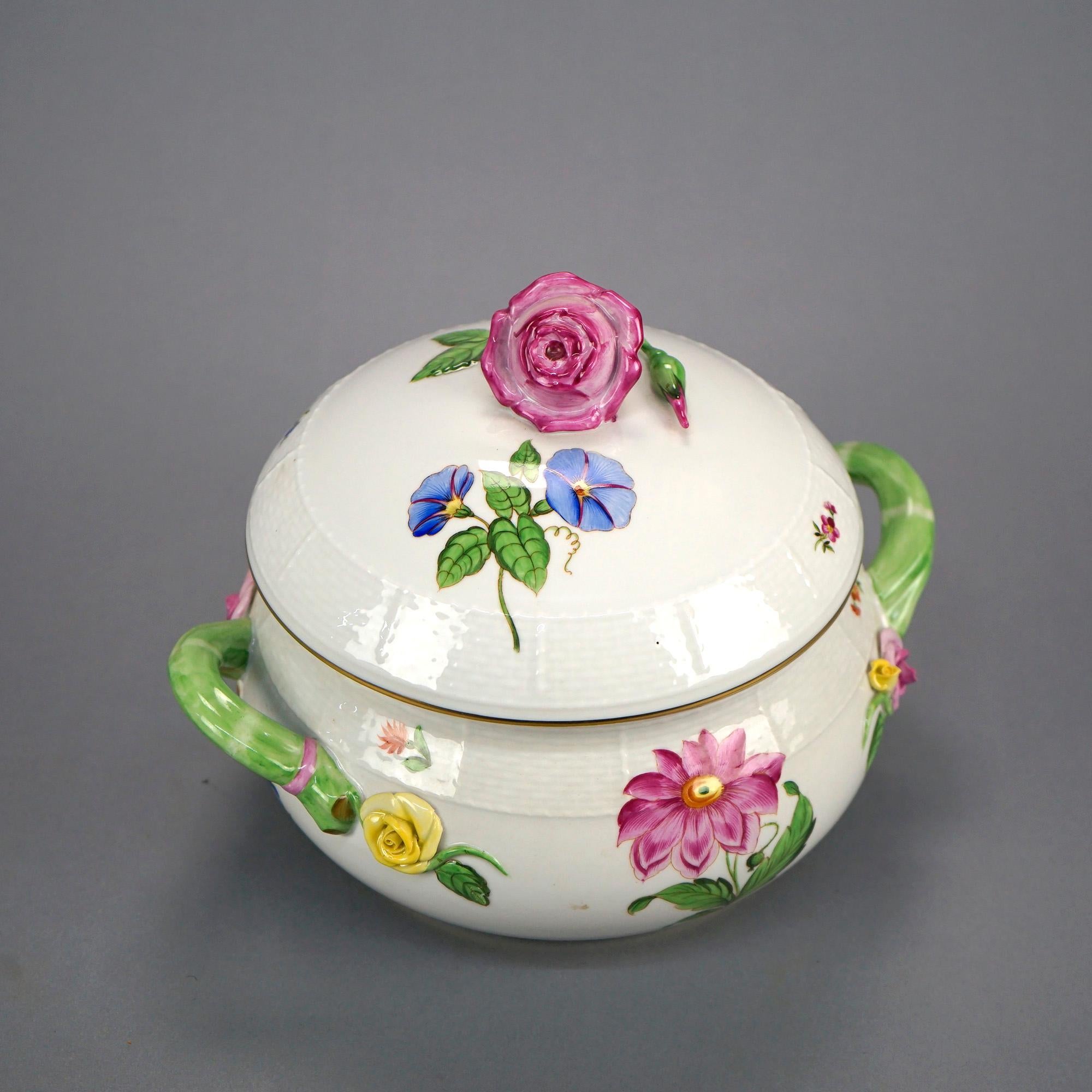 A double handled lidded tureen by Herend offers porcelain construction with hand painted and applied flowers throughout, gilt highlights, maker mark on base as photographed, 20th C

Measures- 8'' H x 10.5'' W x 8.5'' D.