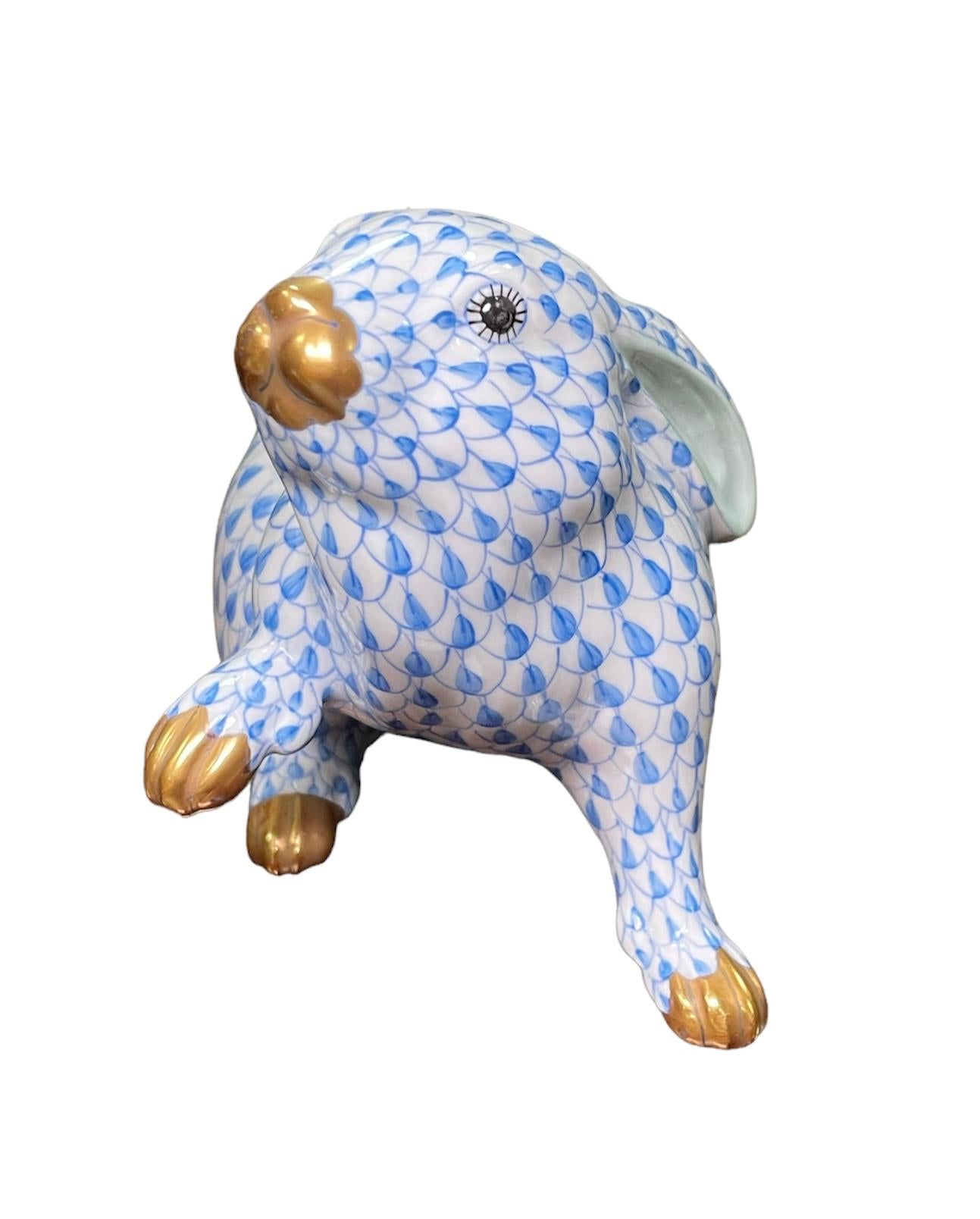 This is a Herend porcelain hand painted friendly and sweet rabbit that has one of its paw up ( like offering you it’s friendship). Its background is white with royal blue fish scale net pattern. The inside of the ears are light green color. The eyes