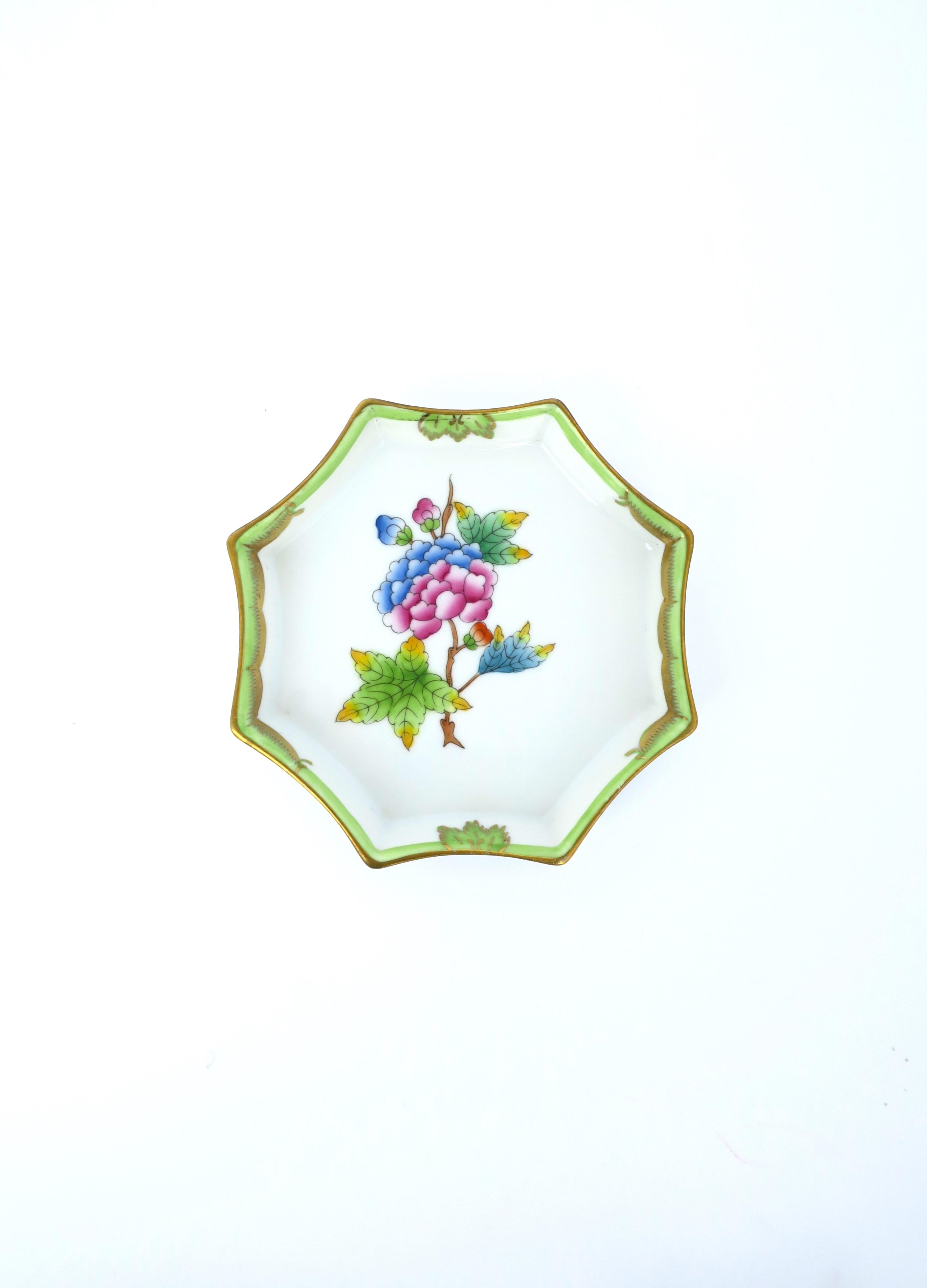 A very beautiful hand painted octagonal porcelain jewelry dish vide-poche from luxury maker Herend, circa 20th century, Hungary. Dish is octagonal with Queen Victoria design, a floral and leaf center and decorative edge finished in gold. Colors are