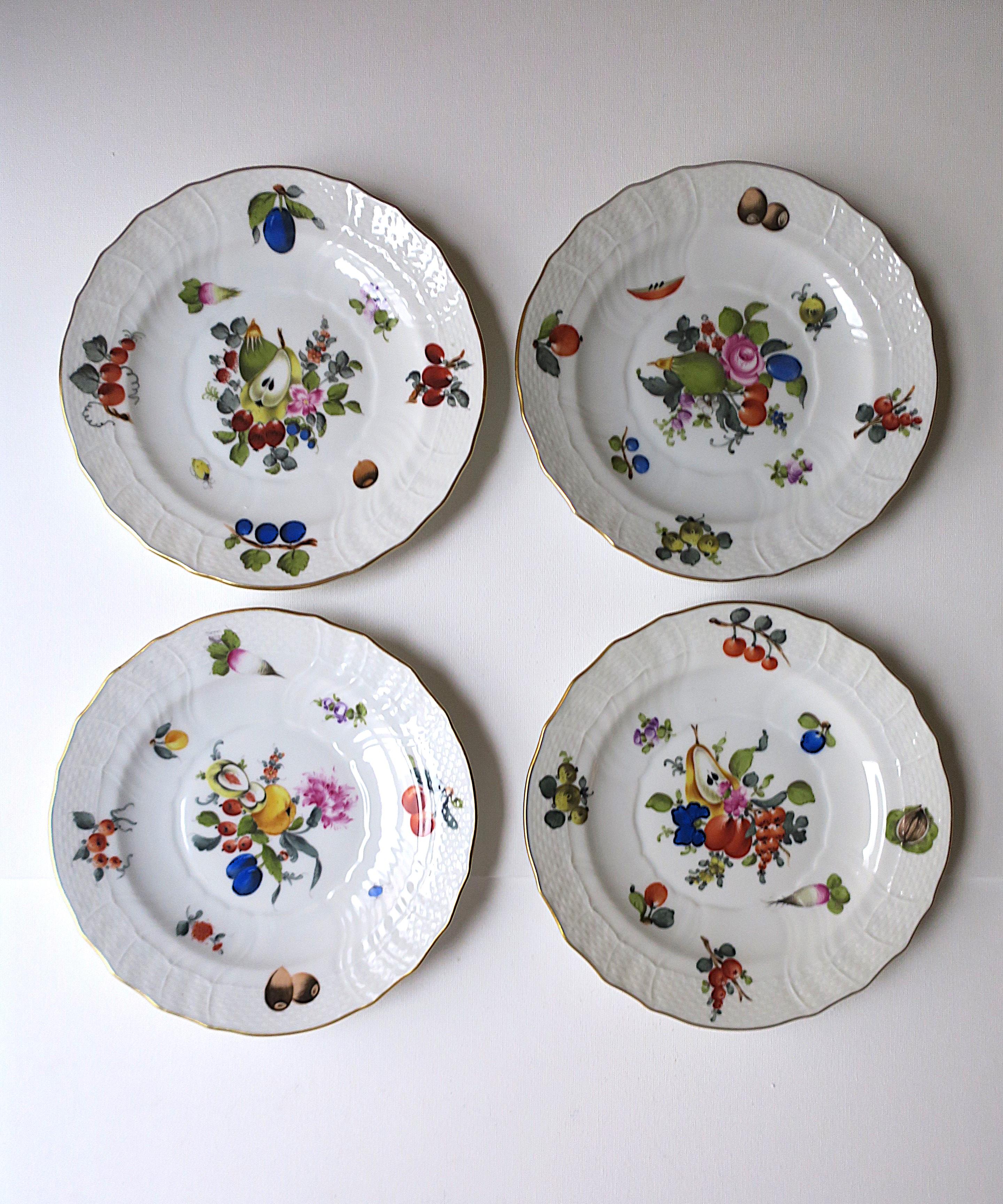 Ein schöner Satz von vier (4) handbemalten Porzellantellern des Luxusherstellers Herand, ca. Mitte des 20. Jahrhunderts, Ungarn. Jeder Teller hat ein wunderschönes handgemaltes Design aus Blumen, Früchten, Gemüse und Nüssen, das mit einem