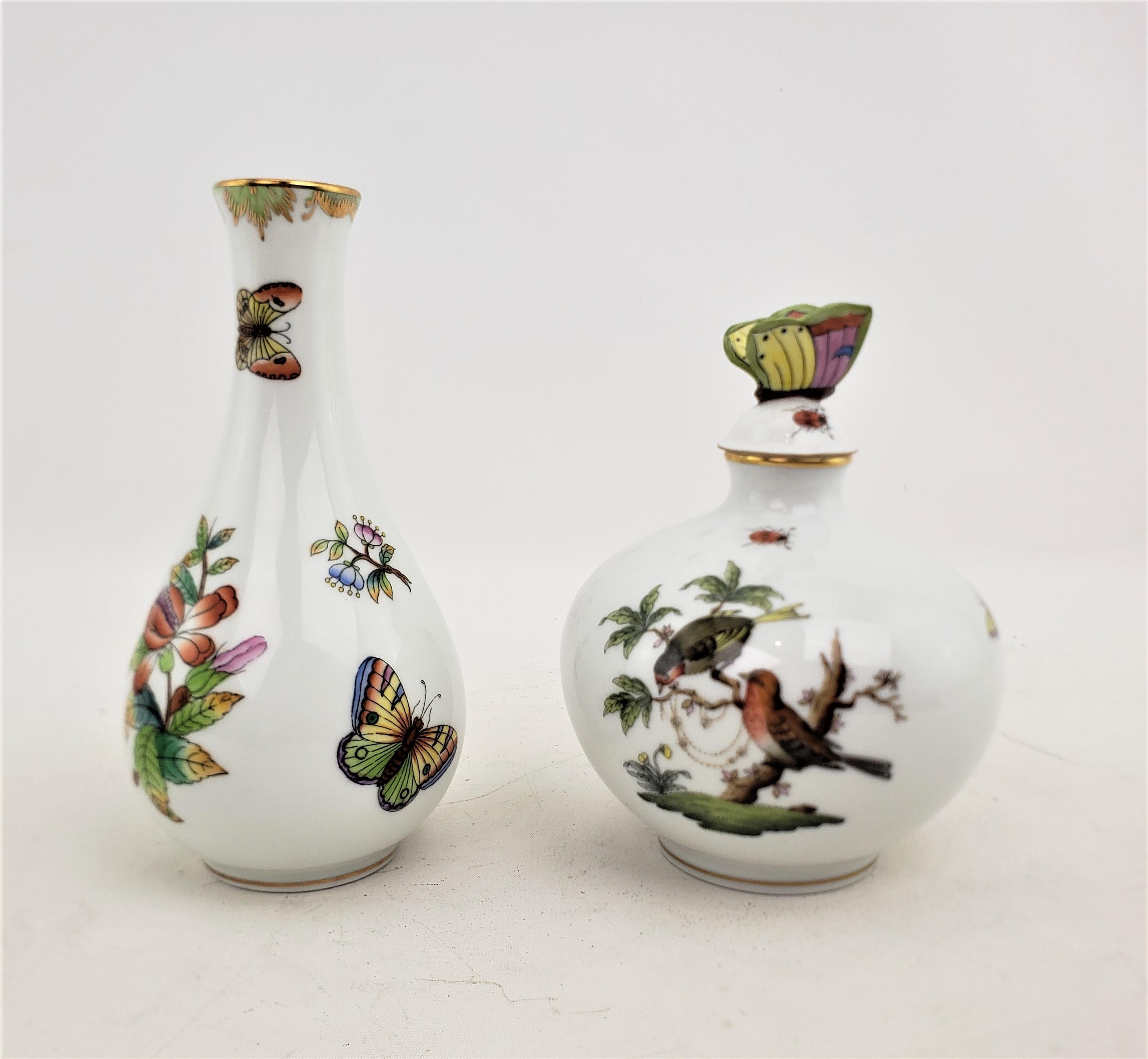 This perfume bottle and vase were both made by the well known Herend factory of Hungary in approximatey 1970 in a Victorian style. The pairing are both composed of porcelain which has been ornately hand painted. The perfume bottle is done in the