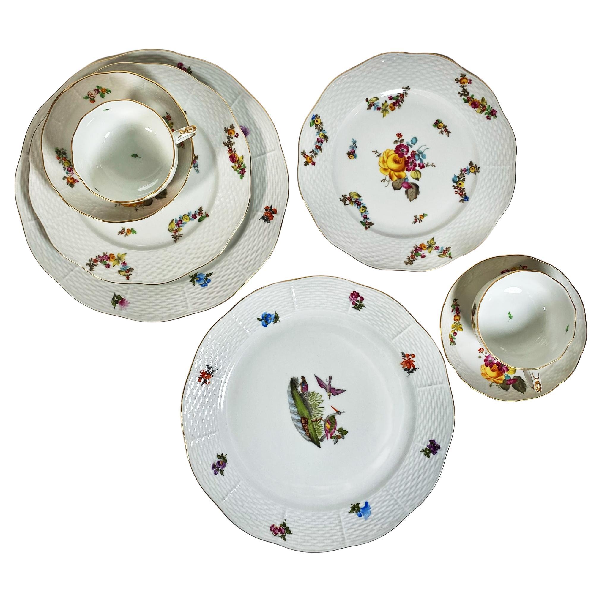 Erleben Sie die zeitlose Eleganz und die exquisite Handwerkskunst dieses atemberaubenden Sets aus Herender Porzellan. Diese Kollektion besticht durch eine Kombination aus farbigen, goldenen, blumigen und pflanzlichen Motiven, die in sorgfältiger