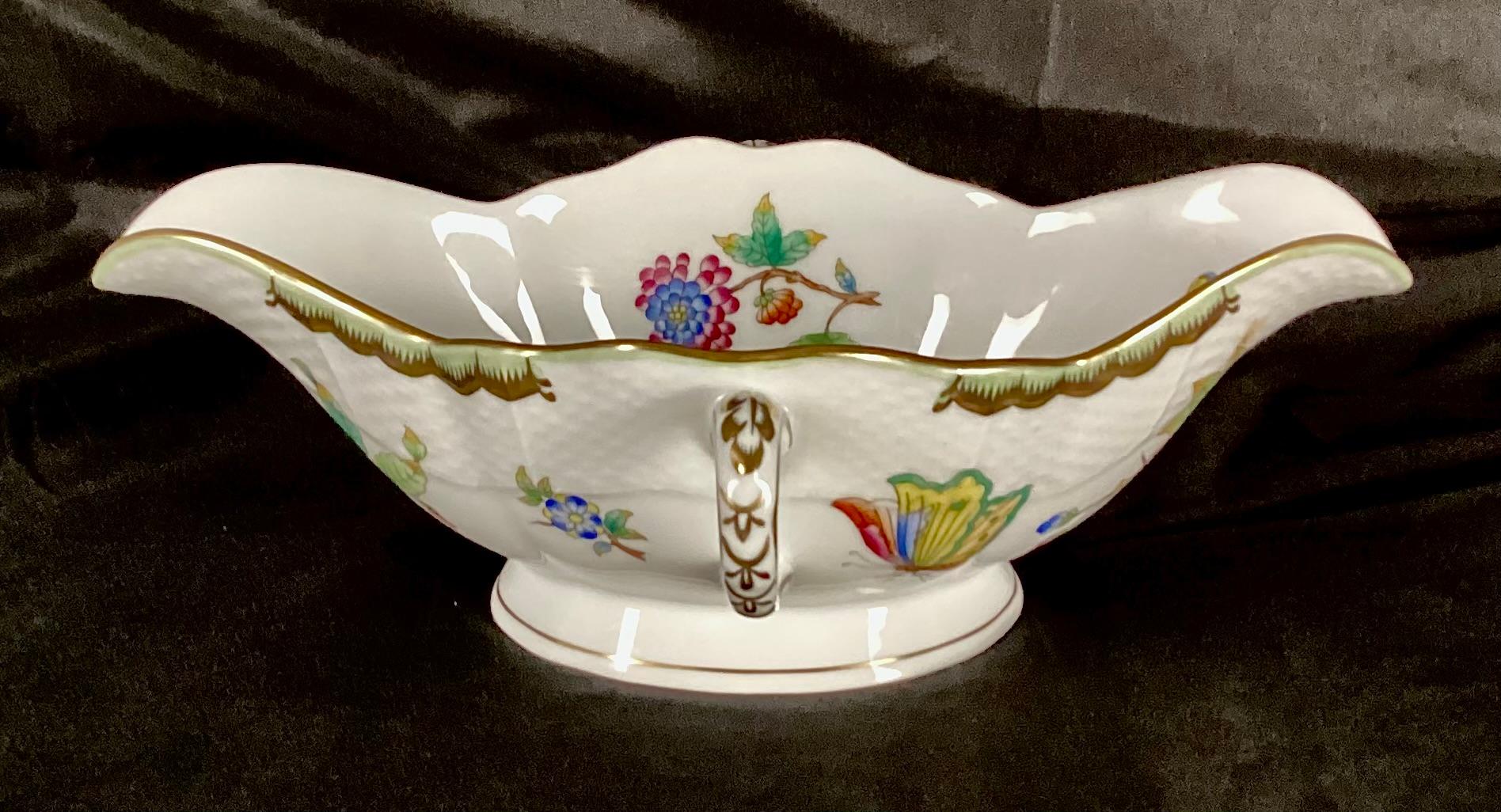 Rare   Herend Queen Victoria Gravy Boat. Gravy boat is hand-painted with butterflies and florals on a white background with gold trim throughout, giving the piece a charming, nature-inspired touch. Ceramic handles on either side. Founded in 1826,
