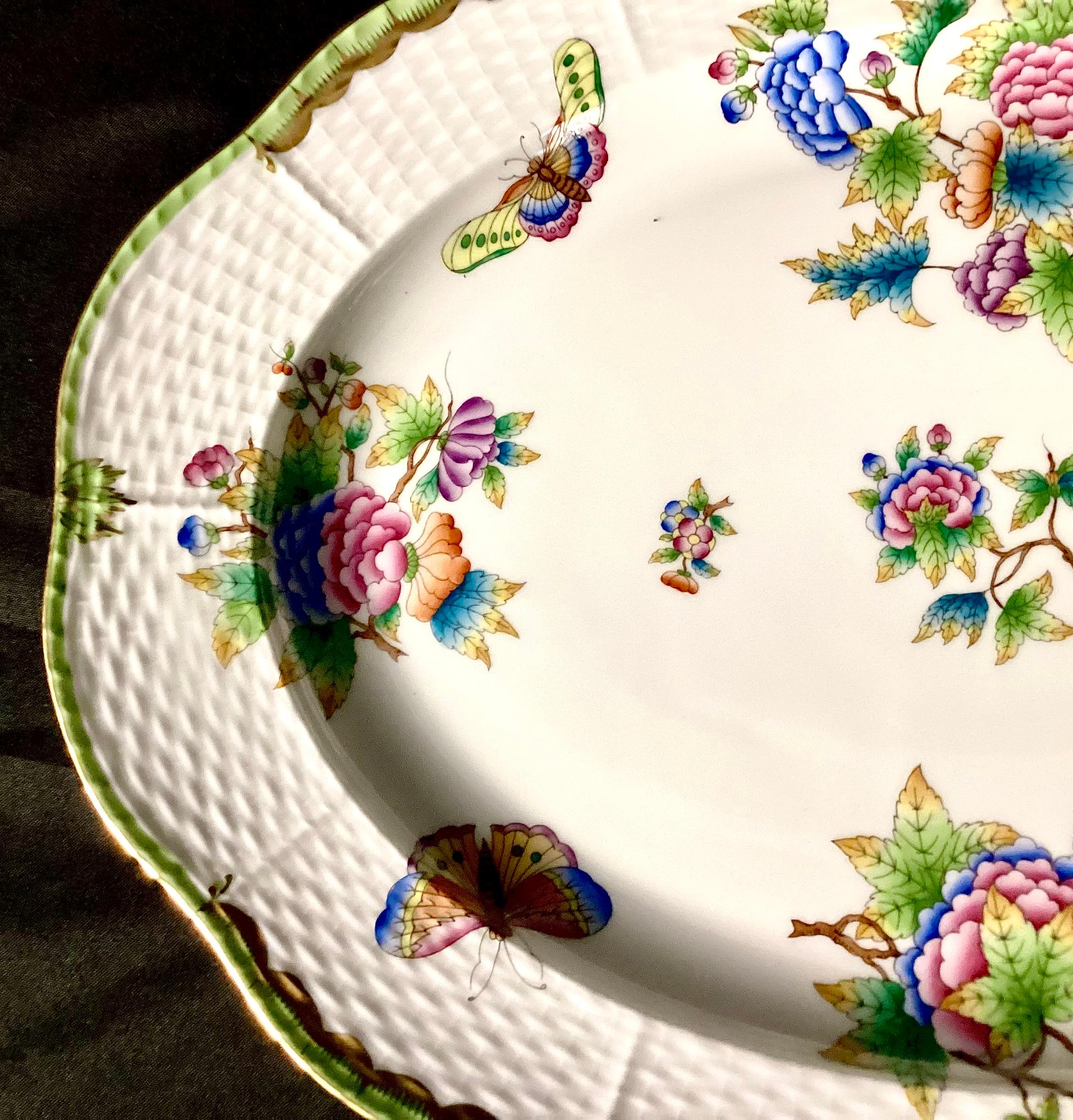 Piatto in porcellana dipinto a mano Herend Queen Victoria del XX secolo. Il piatto grande misura 14 pollici e presenta un motivo floreale e di farfalle su sfondo bianco con rifiniture dorate, che conferiscono al pezzo un tocco affascinante e