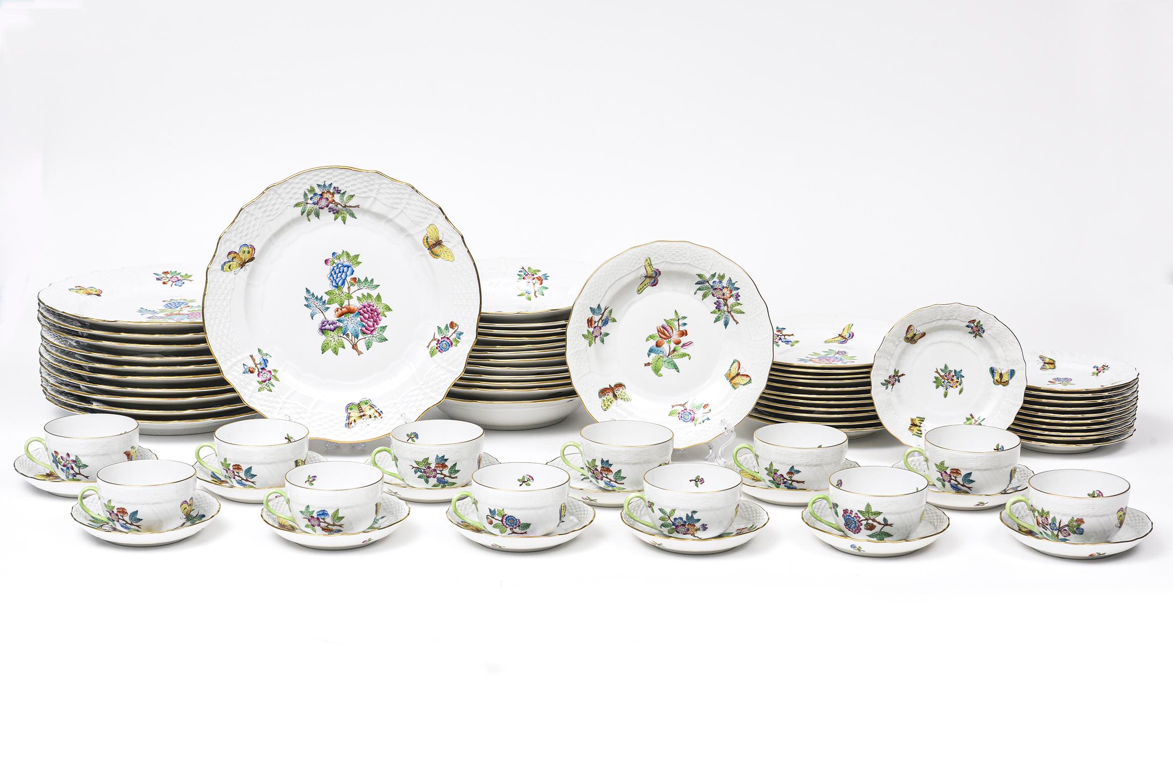 Elegant set of Herend China service for 12 minus 2 pieces (70 pieces in total). This is the older pattern of Queen Victoria that does not have the green border. It has a weave rim and a gold edge. The pattern features flowers and butterflies. Please