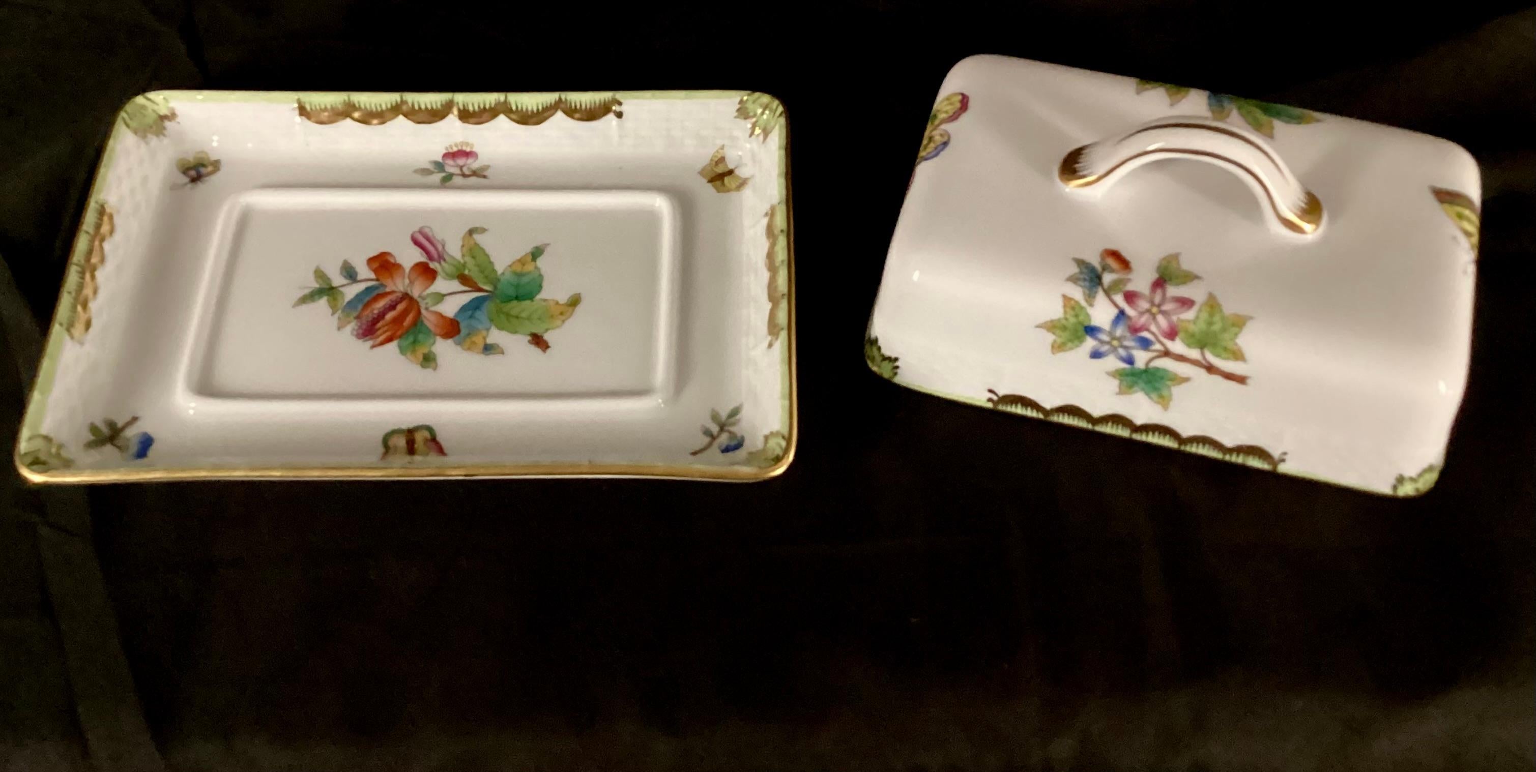 Rettangolo raro  Piatto da burro Herend Queen Victoria. La parte superiore e il fondo piatto sono dipinti a mano con farfalle e fiori su sfondo bianco e rifiniture dorate, per dare al pezzo un tocco affascinante e ispirato alla natura. Fondata nel