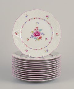 Herend, juego de doce platos de porcelana con motivos florales policromados.