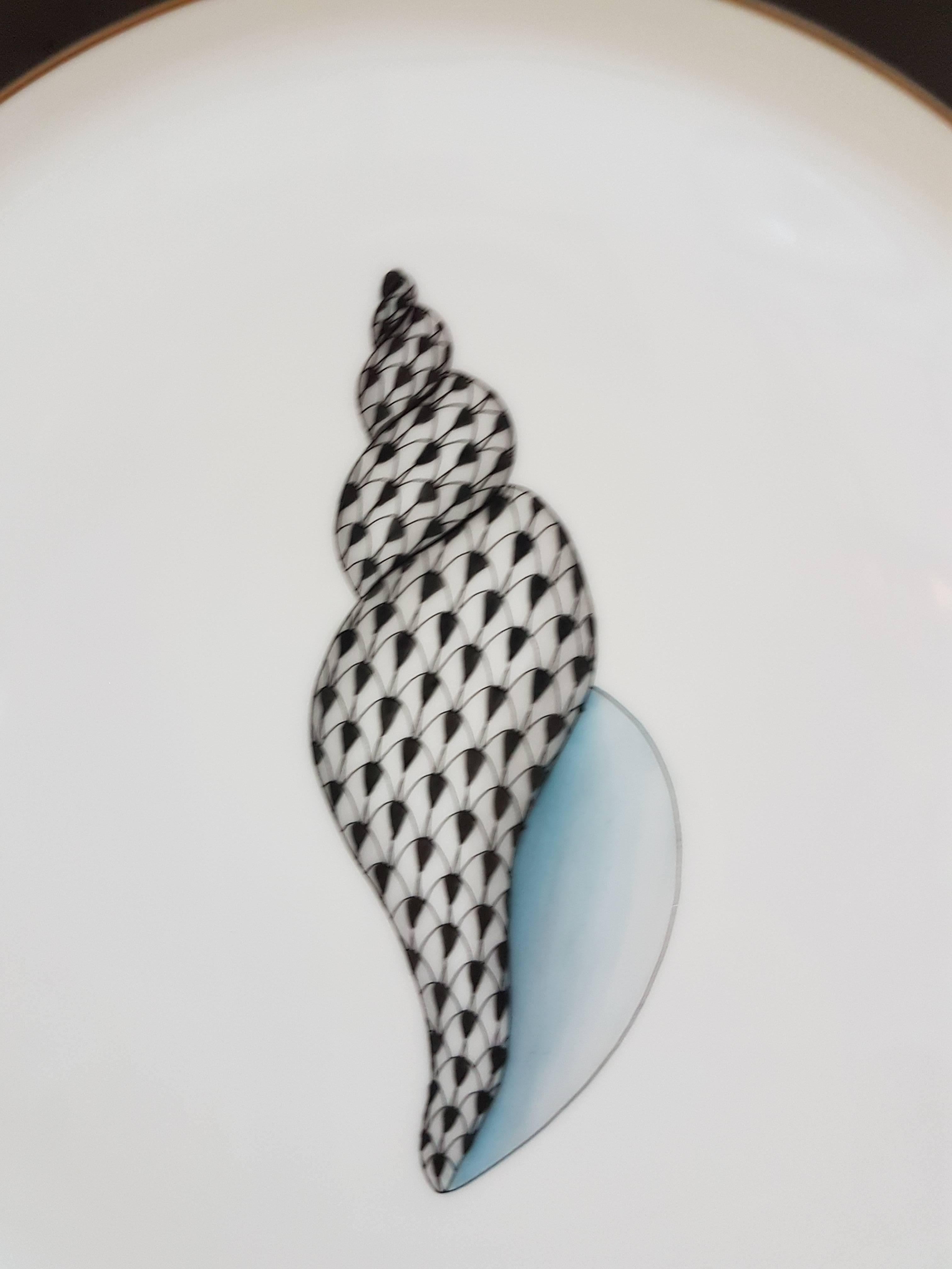 Beautiful hand painted polychrome and gilt porcelain dessert plate; decorated with a shell, band in marbled black painting, border in gold.
Since 1826 Herend has become one of the most famous centers of hand painted porcelain.
Modern.