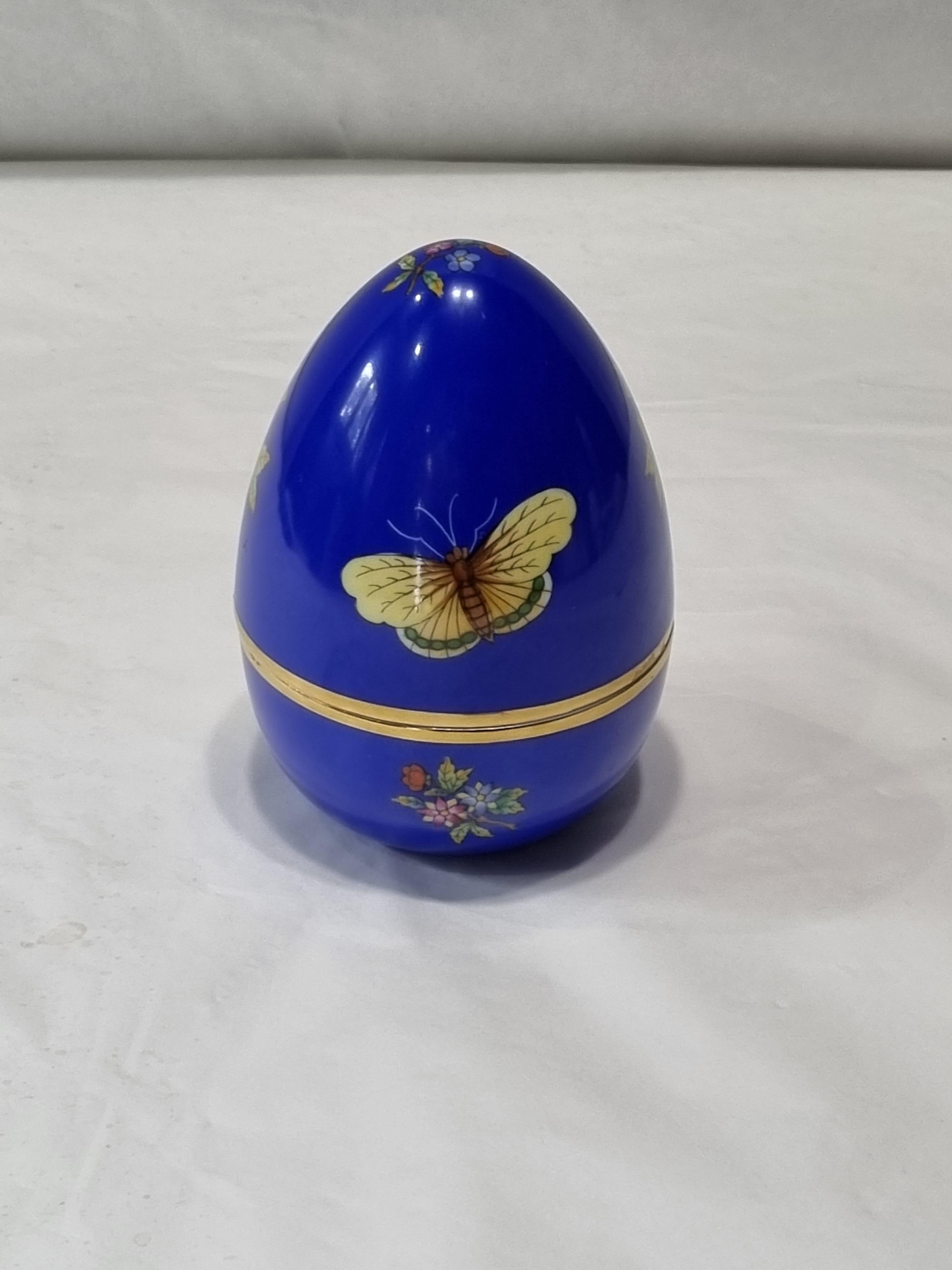 Stylish egg shaped box in Hungarian porcelain hand painted with flowers and butterflies decoration, multi-color, on a blue background.
The Victoria decor is one of the most important of Herend since it was chosen by the great Queen Victoria in 1851