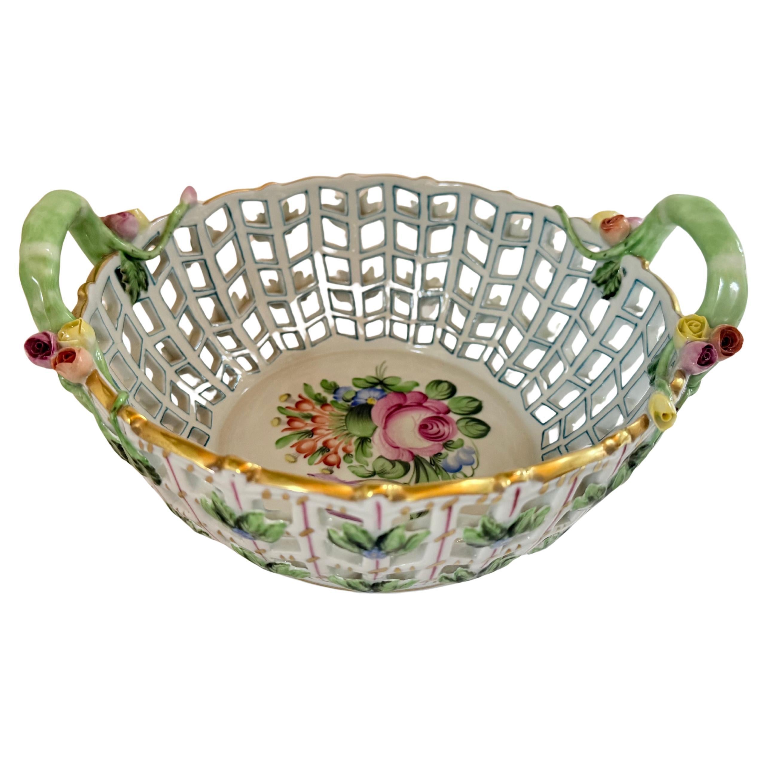 Richly detailed and hued flowers adorn the interior of this elegant porcelain basket. The rim and body boast beautifully detailed openwork, decorated with 24k gold embellishments interlaced with floral motifs. Suitable as a fruit bowl or centerpiece