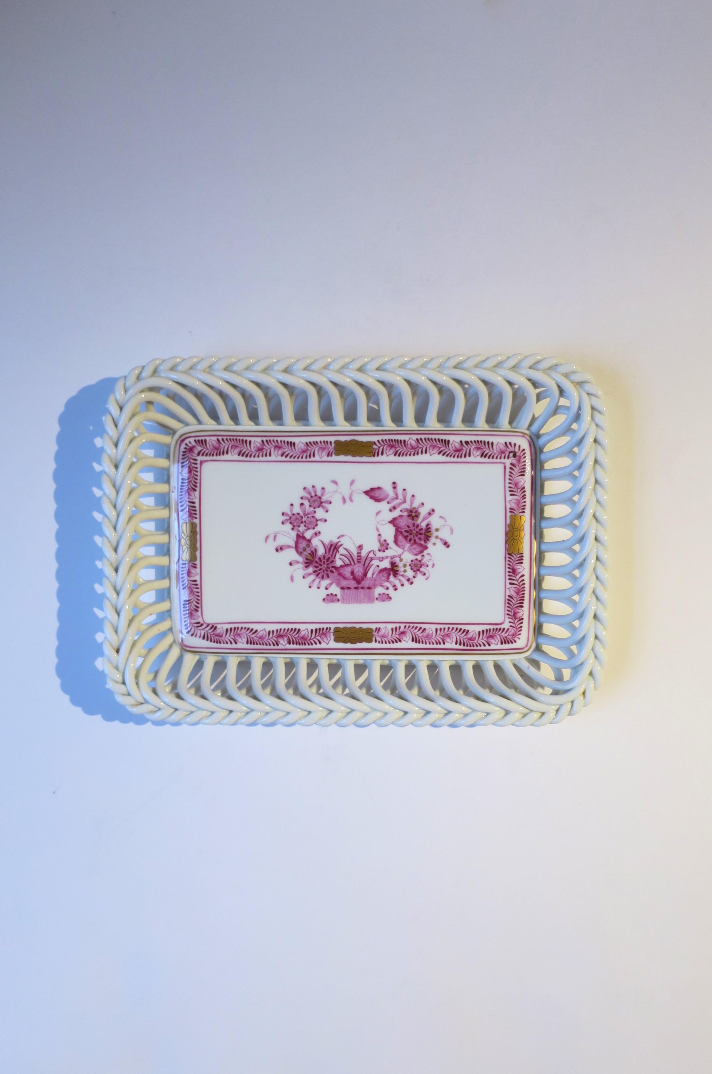 A beautiful white porcelain tray dish vide-poche by luxury marker Herend, circa 20th century, Hungary. This rectangular porcelain tray has a latticework open design, braided edge, and a magenta pink and gold detail around inside edge and center. A