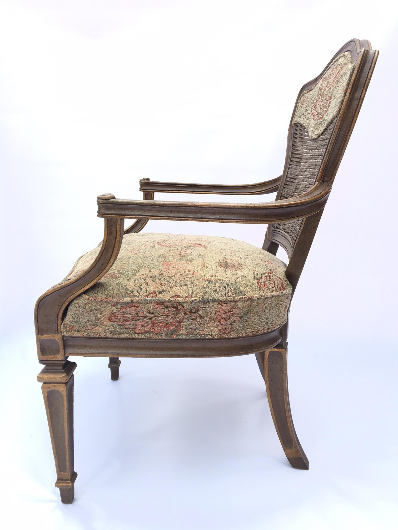 Pair of cane back arm chairs upholstered in floral tapestry. Good vintage condition with minor wear consistent with age.