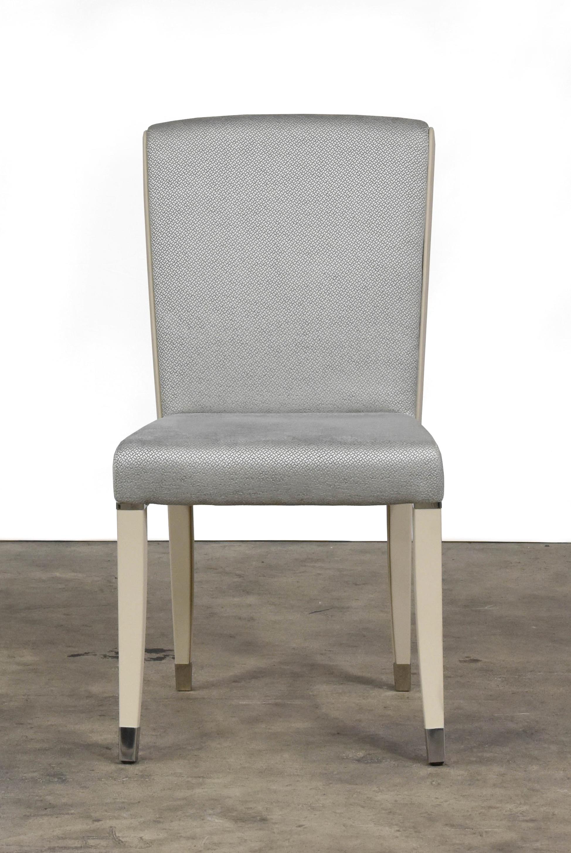 The Aline chair is an elegant option upholstered in ice blue fabric with profile and legs in ivory leather. The chair and legs feature accents in stainless steel.
 