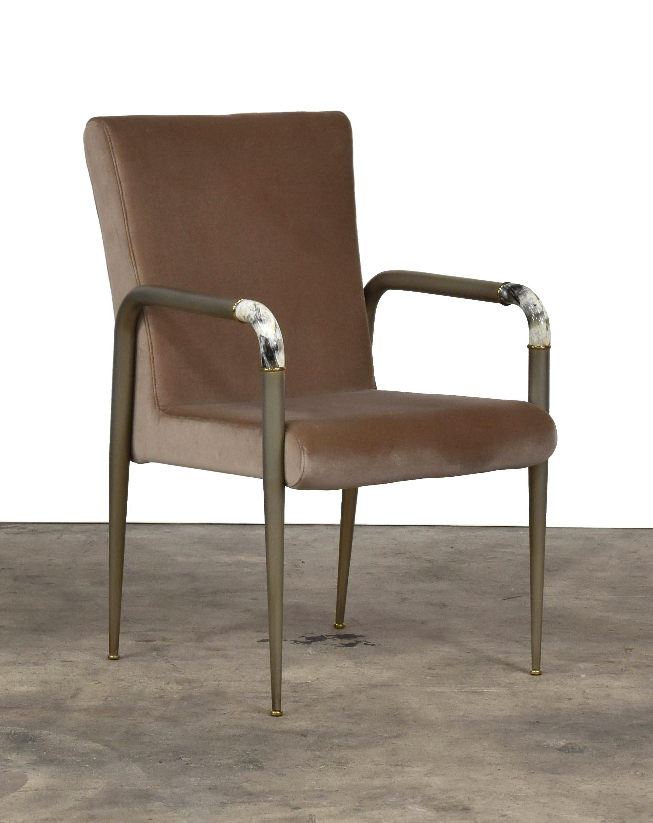 The Cornelius armchair is upholstered in taupe velvet with horn detail and bronze trim around the arm. 
 