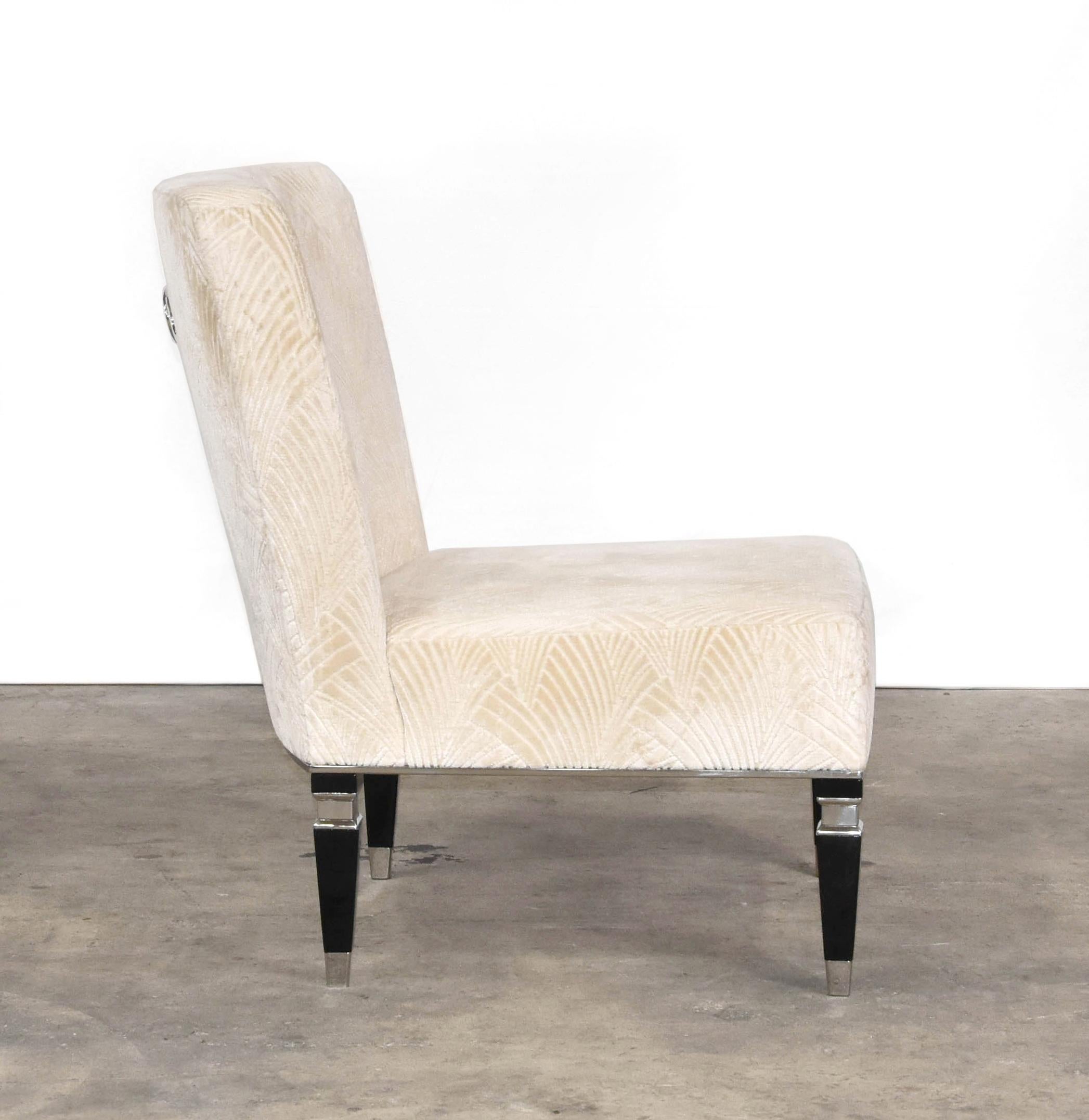 The Geneve Regency armchair features a deep seat upholstered in Art Deco inspired cream velvet, black lacquered feet and stainless steel accents.
 