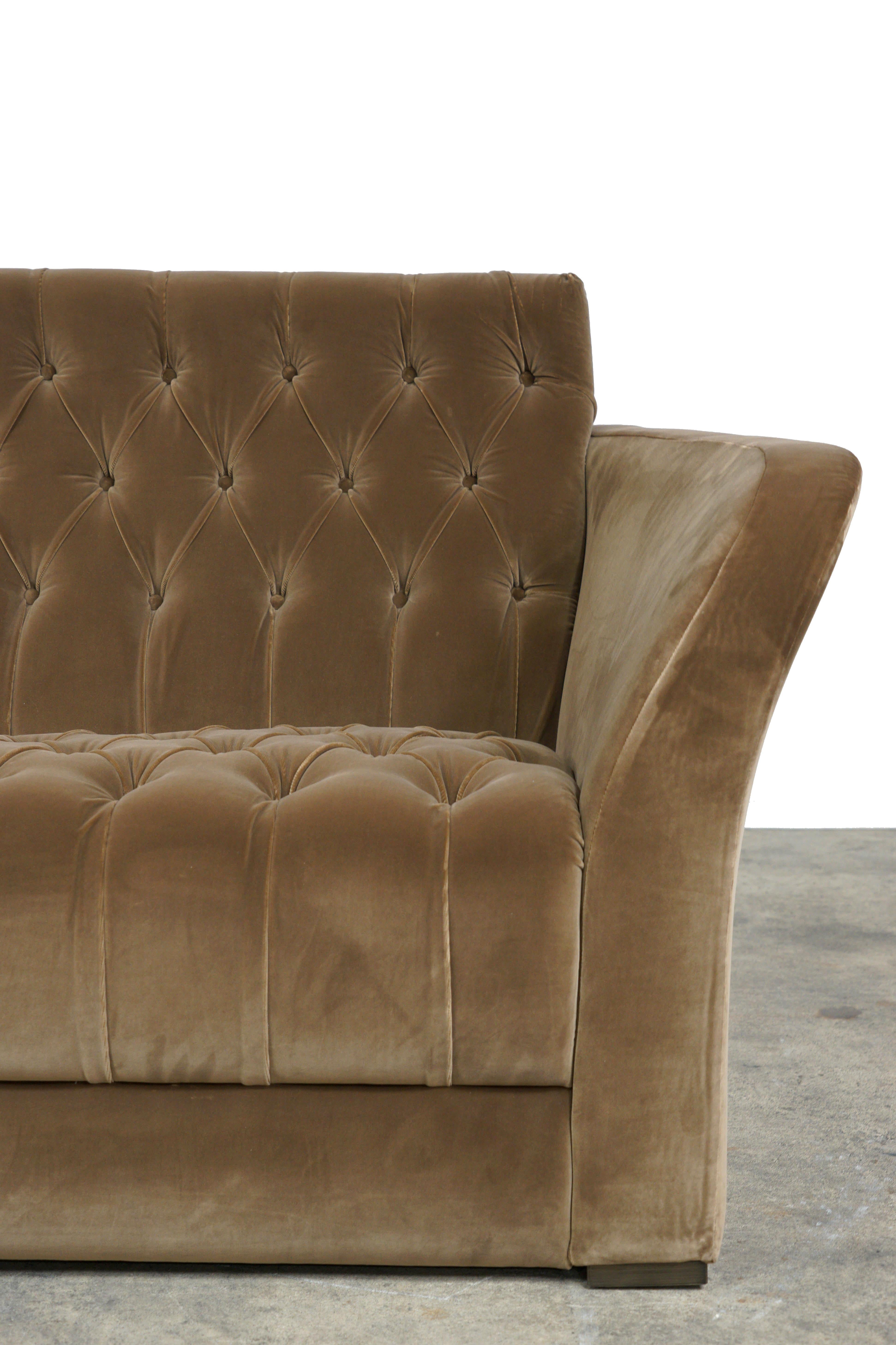 The Rivoli is upholstered in dark taupe velvet with tufted back and seat. With arms gently curving outwards, the sofa feels warm and inviting. It is a transitional piece that brings in traditional elements while maintaining modern sensibilities.
   