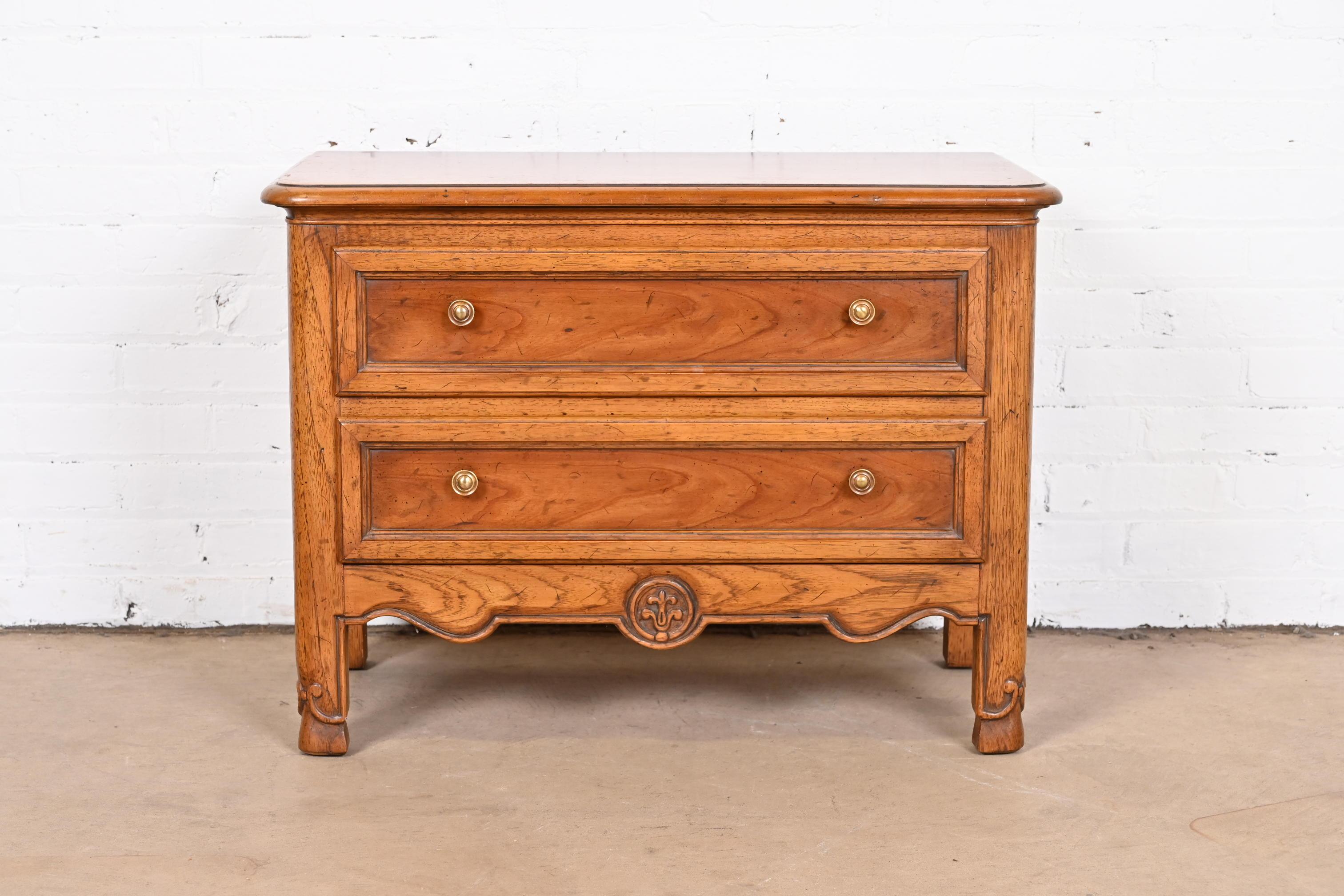 A gorgeous French Provincial Louis XV style bedside chest, commode, or side table

By Heritage

USA, Circa 1960s

Carved walnut and oak, with original brass hardware.

Measures: 30.25