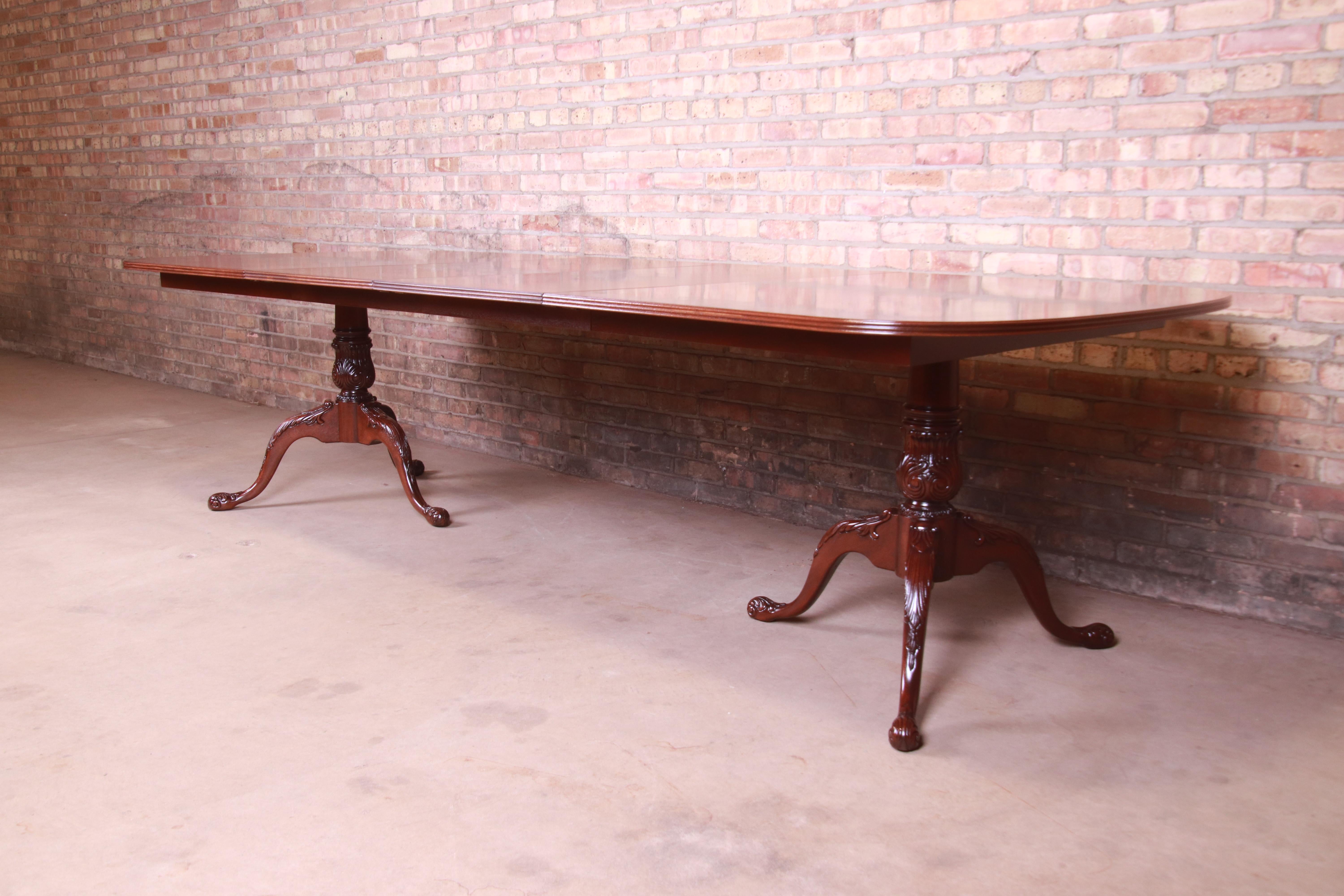An exceptional Georgian style double pedestal extension dining table

By Heritage Furniture

USA, circa 1980s

Bookmatched mahogany with satinwood banding, and carved solid mahogany pedestals.

Measures: 73.5