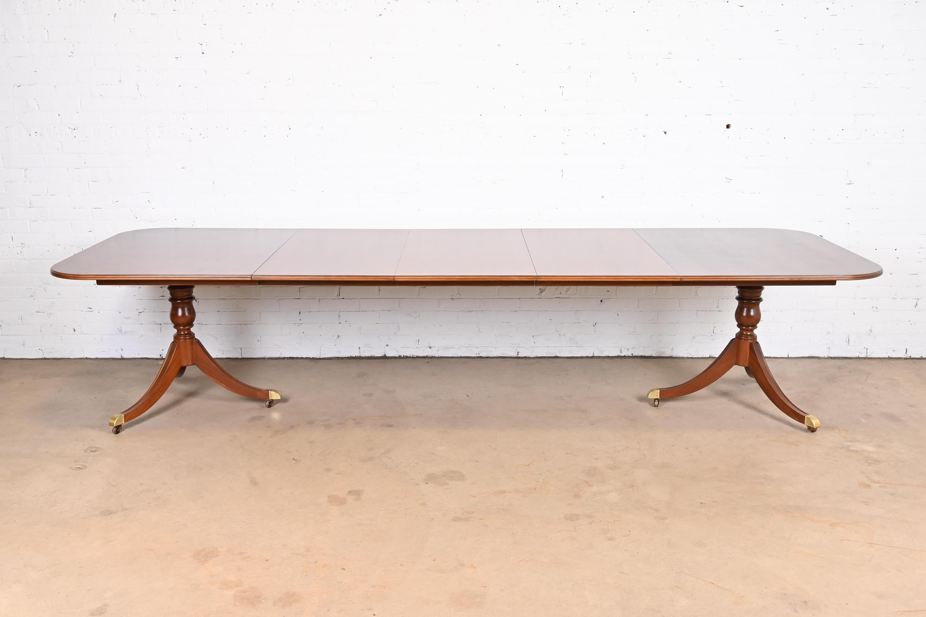 An exceptional Georgian or Regency style double pedestal extension dining table

By Heritage

USA, Circa 1980s

Stunning mahogany with starburst design on the table top, with yew wood banding, carved solid mahogany pedestals, and brass-capped feet