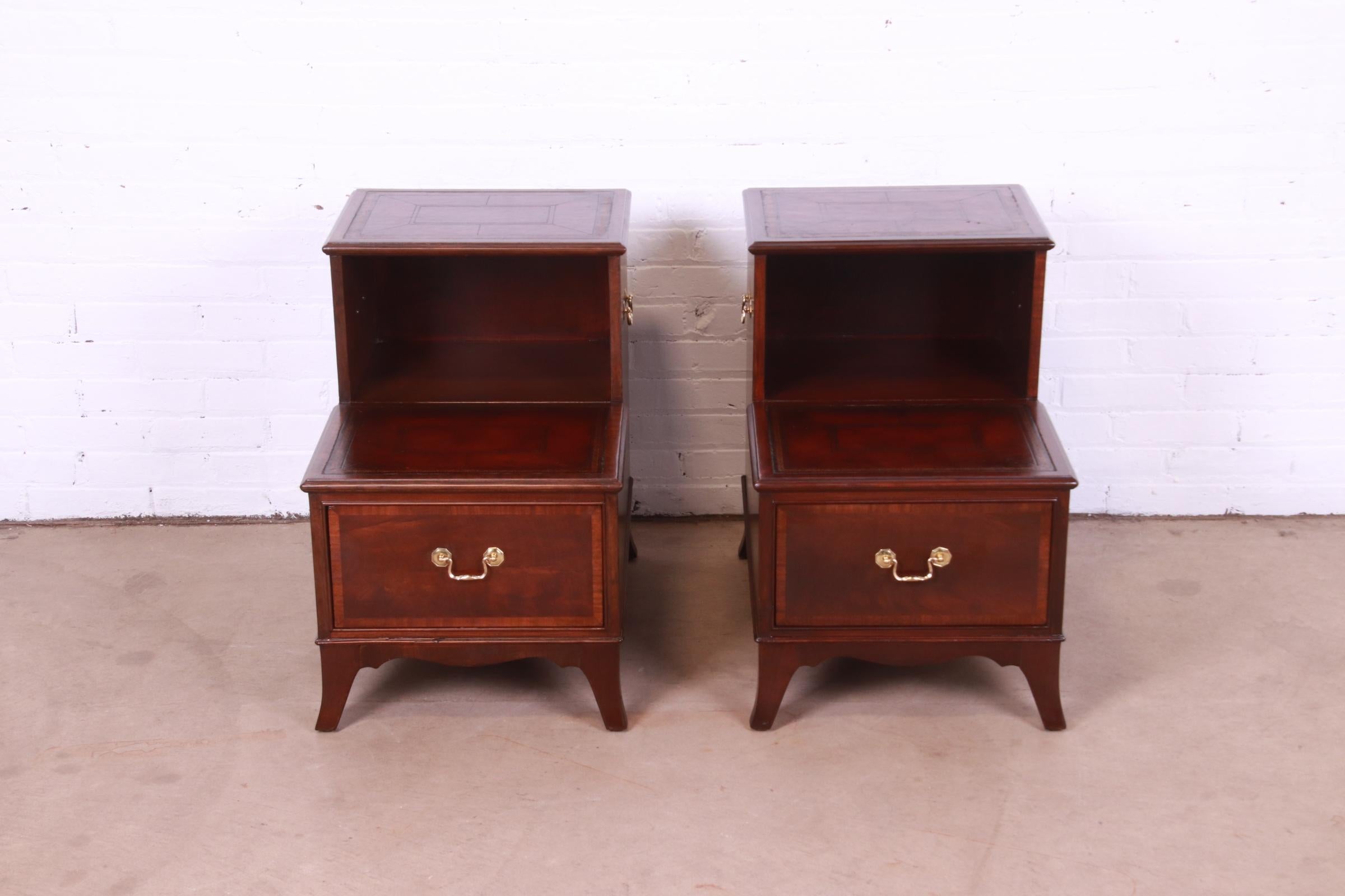 A gorgeous pair of Georgian style two-tier occasional step end tables or nightstands

By Heritage

USA, Mid-20th Century

Mahogany, with embossed leather tops, and original brass hardware.

Measures: 18