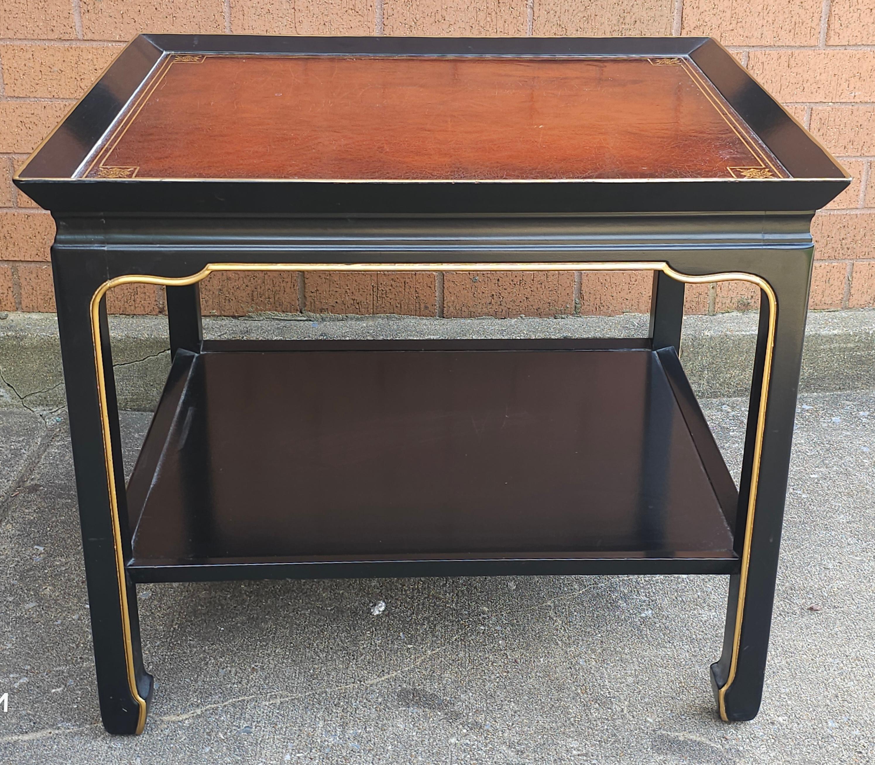Table d'appoint à deux niveaux, de style Henredon, ébonisée et dorée à la feuille. Dessus en cuir tolé.
 En excellent état vintage. Mesure 22,25