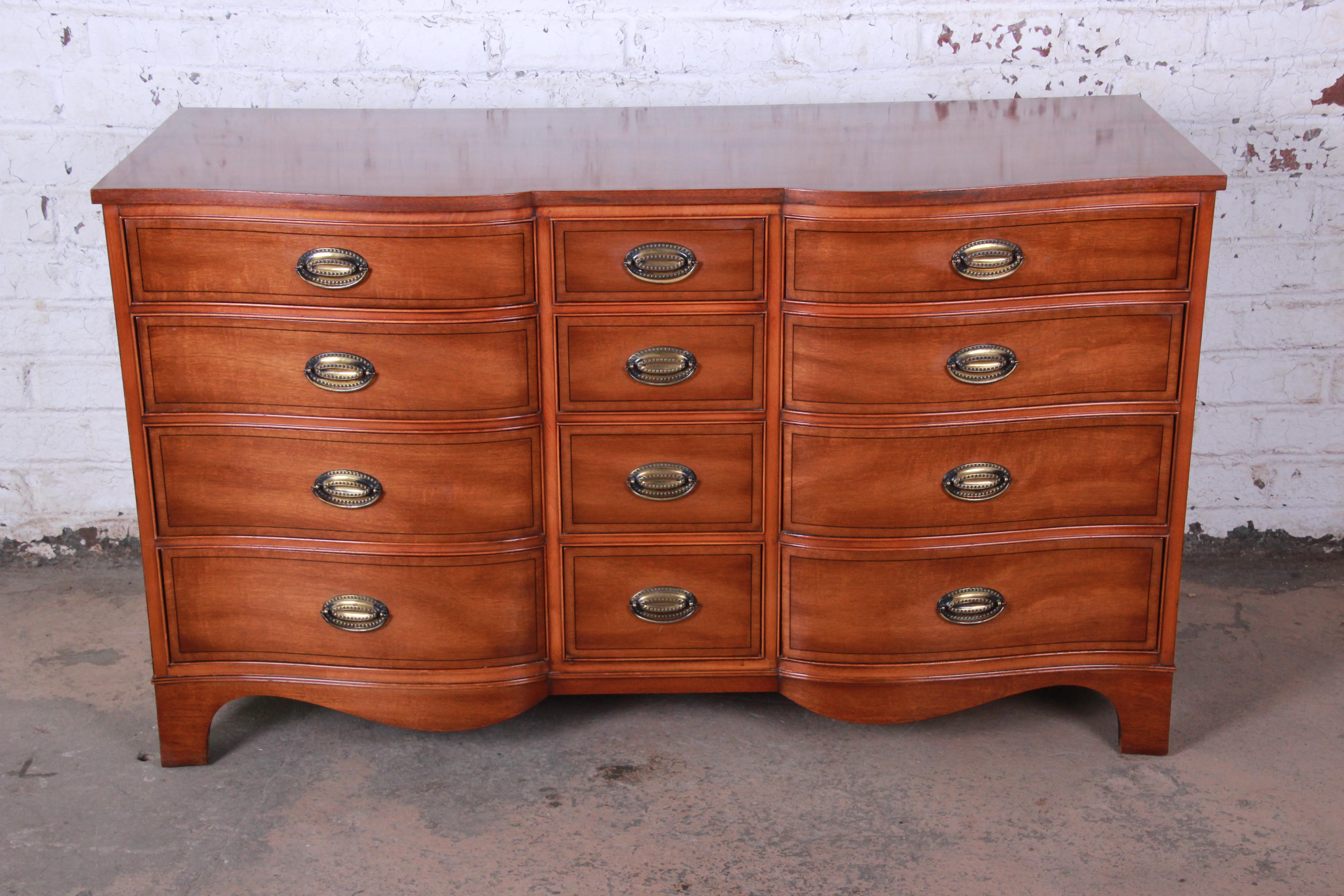 A gorgeous inlaid mahogany twelve-drawer dresser by Heritage Henredon. The dresser features stunning mahogany wood grain and a nice traditional style. It offers ample storage, with twelve deep dovetailed drawers. The original Heritage Henredon label