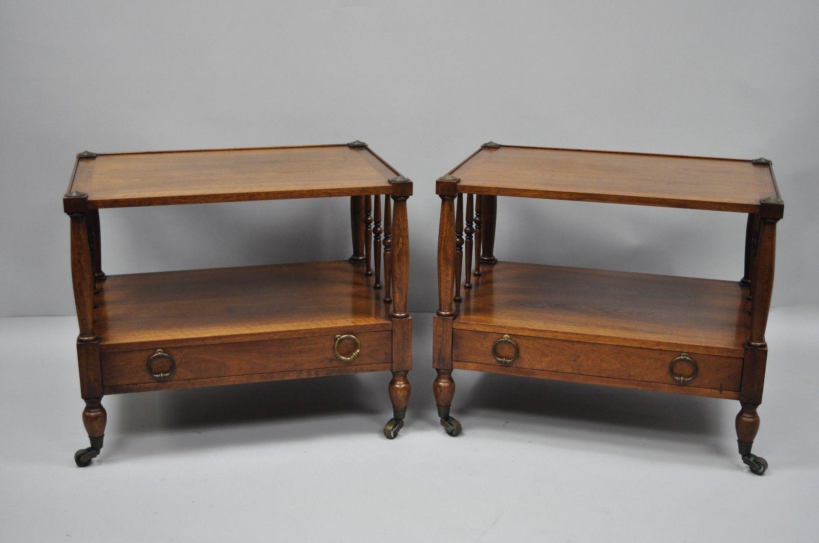 Heritage Henredon Regency style banded walnut wide end tables a pair. Item features nice wide forms, spindle sides, banded tops, brass medallions, brass rolling casters and drop pulls, beautiful wood grain, original stamp, and one dovetailed drawer,