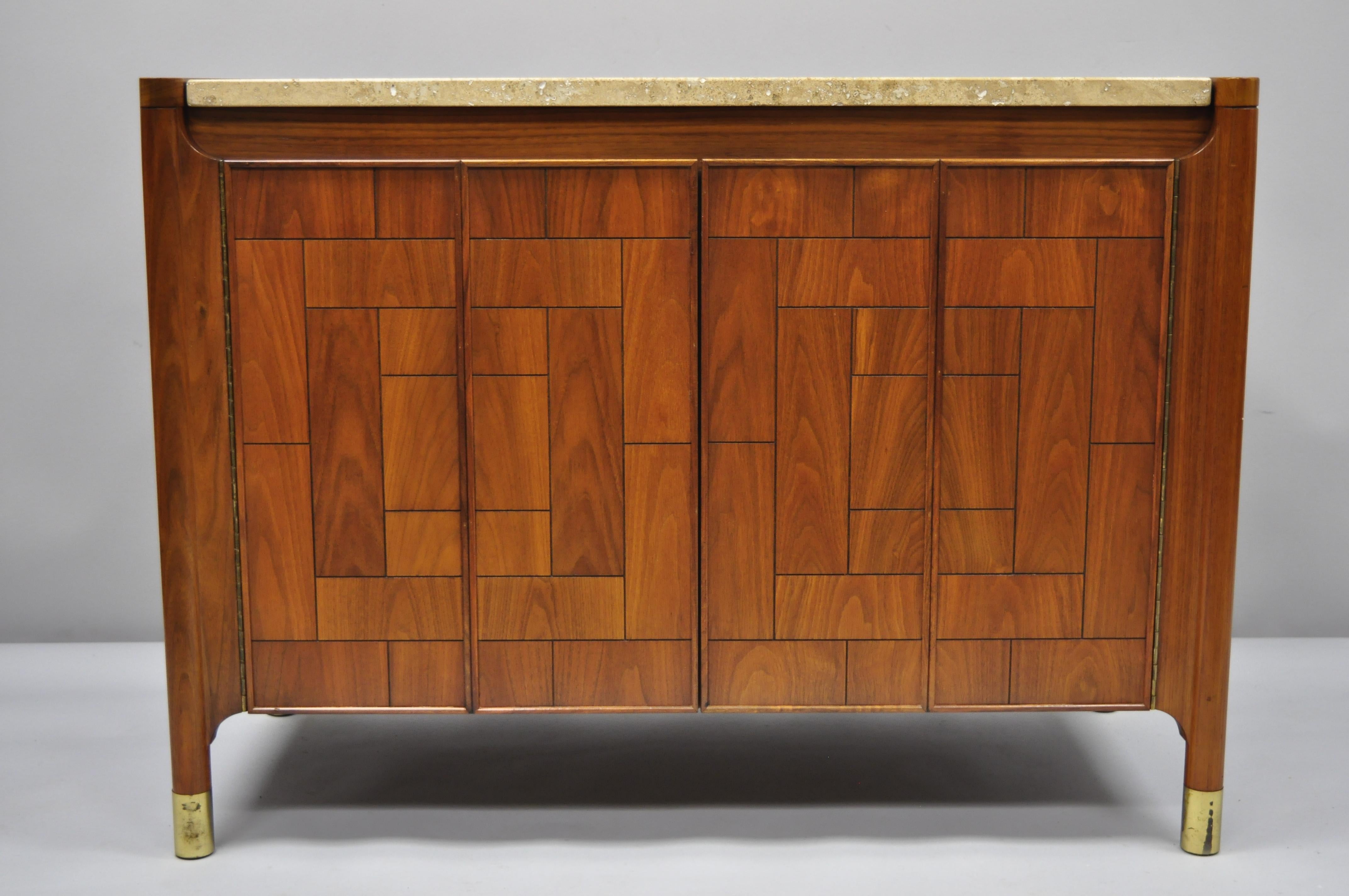 Heritage Henredon walnut and travertine top Mid-Century Modern server cabinet. Item features travertine stone top, walnut case, geometric door fronts, brass capped feet, beautiful wood grain, finished back, 2 swing doors, original stamp, one
