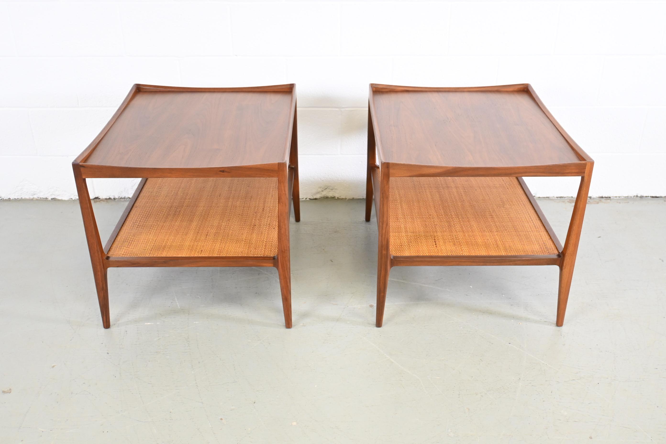 Heritage Mid-Century Modern pair of end or side tables

Heritage Furniture, USA, 1950s

23 Wide x 28 Deep x 22 High

Mid century modern walnut set of end or side tables with woven rattan on shelf.

Professionally refinished. Excellent condition.