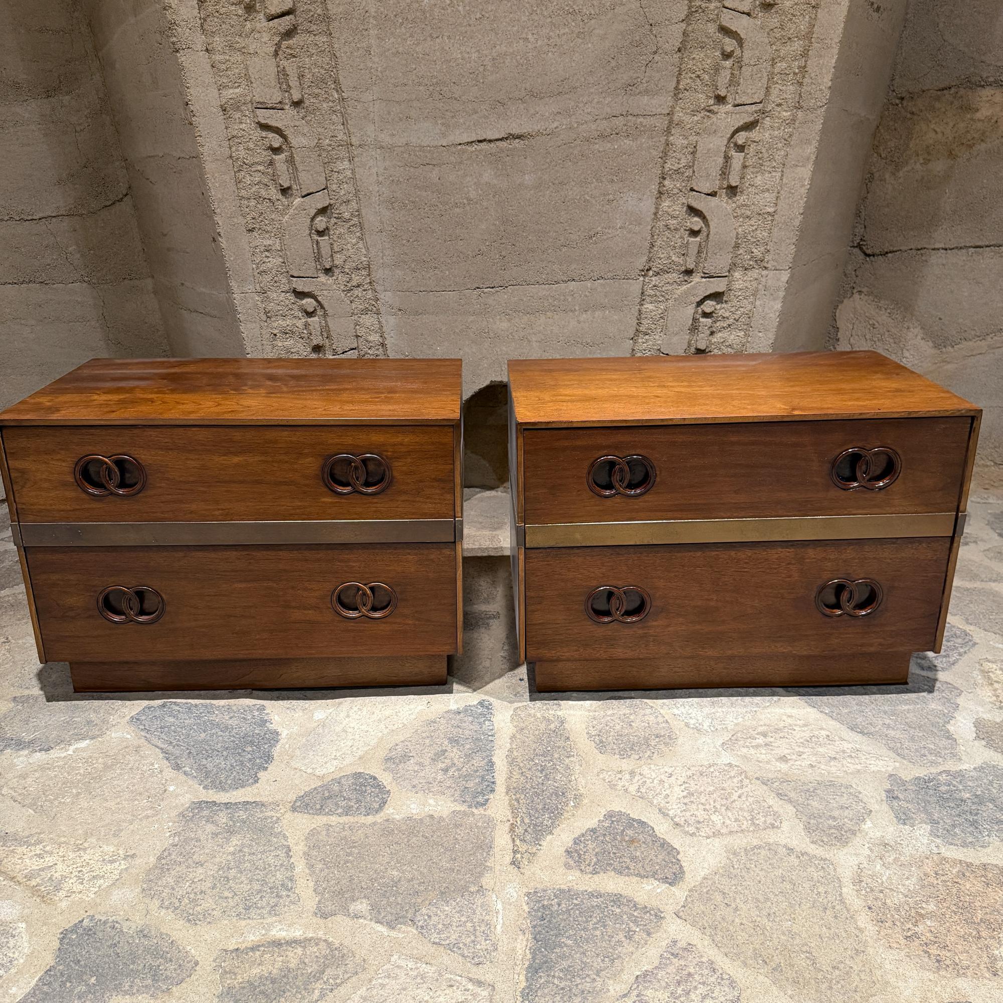 Pour votre considération, une paire de tables de nuit de style moderne du milieu du siècle par Heritage. Michael Taylor a réalisé un tirage similaire pour BAKER. Bois de noyer avec accent en laiton. Intérieurs propres. La finition a été rafraîchie.