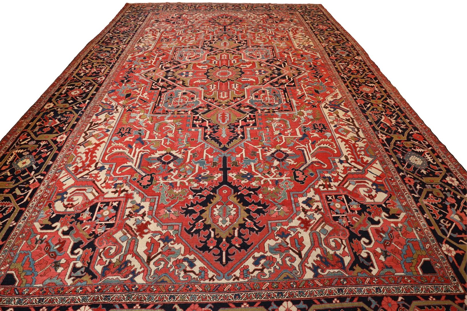 This antique Heriz room size rug is truly a masterpiece of design, craftsmanship, and beauty. The rich and deep red background instantly captures the eye and creates a sense of warmth and elegance that permeates the entire room.

At the center of