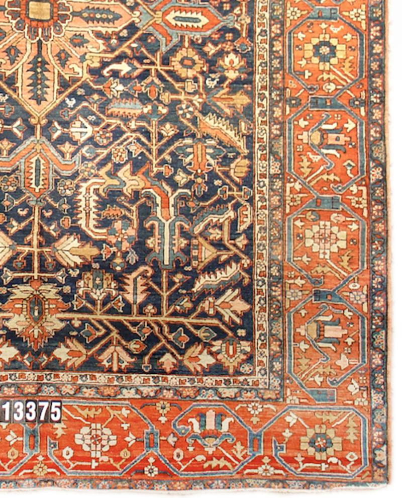 This Heriz rug from Northwest Persia draws a small diamond-shaped medallion against an ornamented navy ground. Lush foliage and blossoms issue forth from horizontal beams at the top and bottom, seemingly hanging from both directions towards the