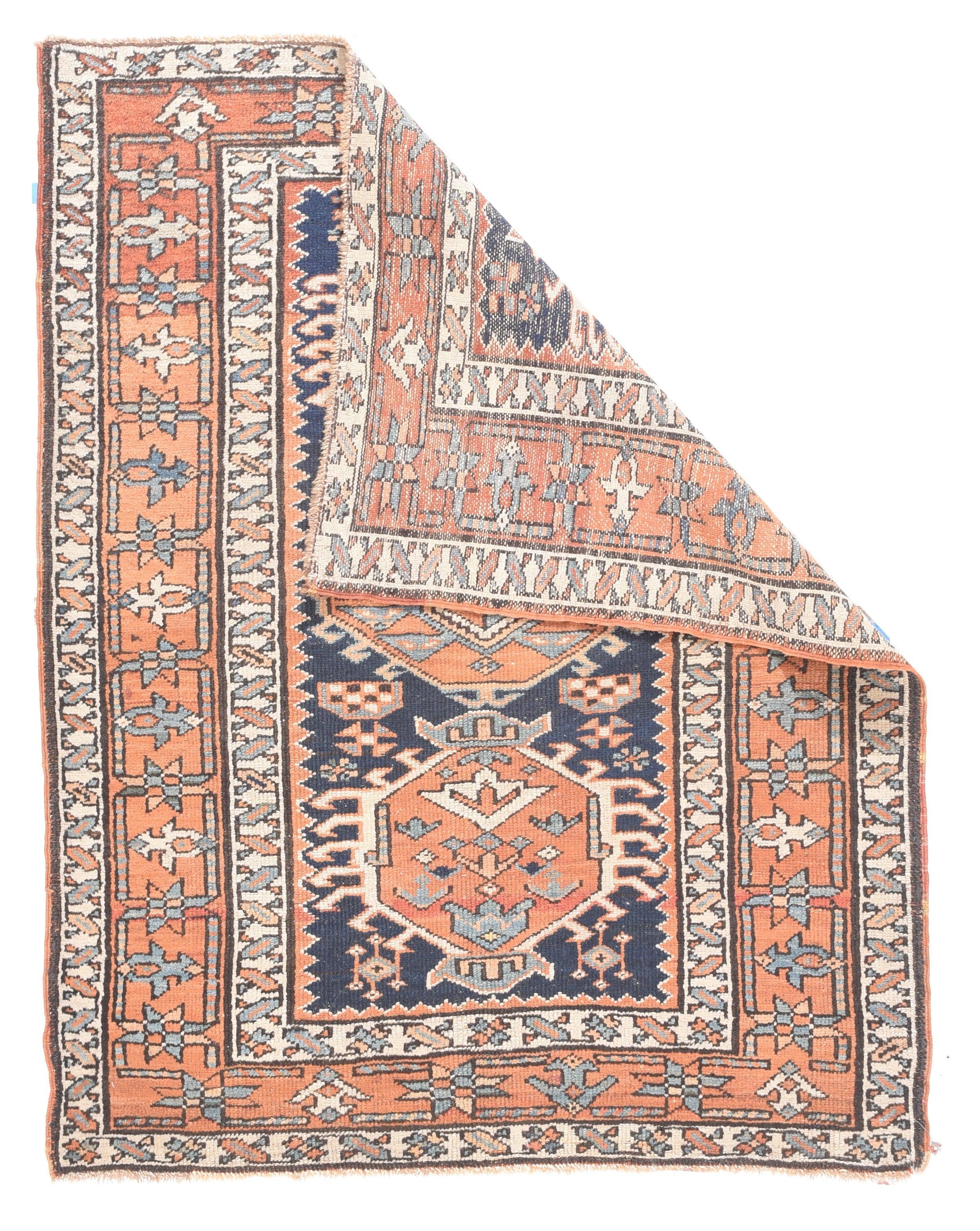 Heriz Rug 3'4'' x 4'3''. The deep indigo field barely contains three abrashed rust medallions, two with ivory hooked fringes and a central lozenge with a green kilim-style centre. Rust main border with connected stars and ultra-simple palmettes.