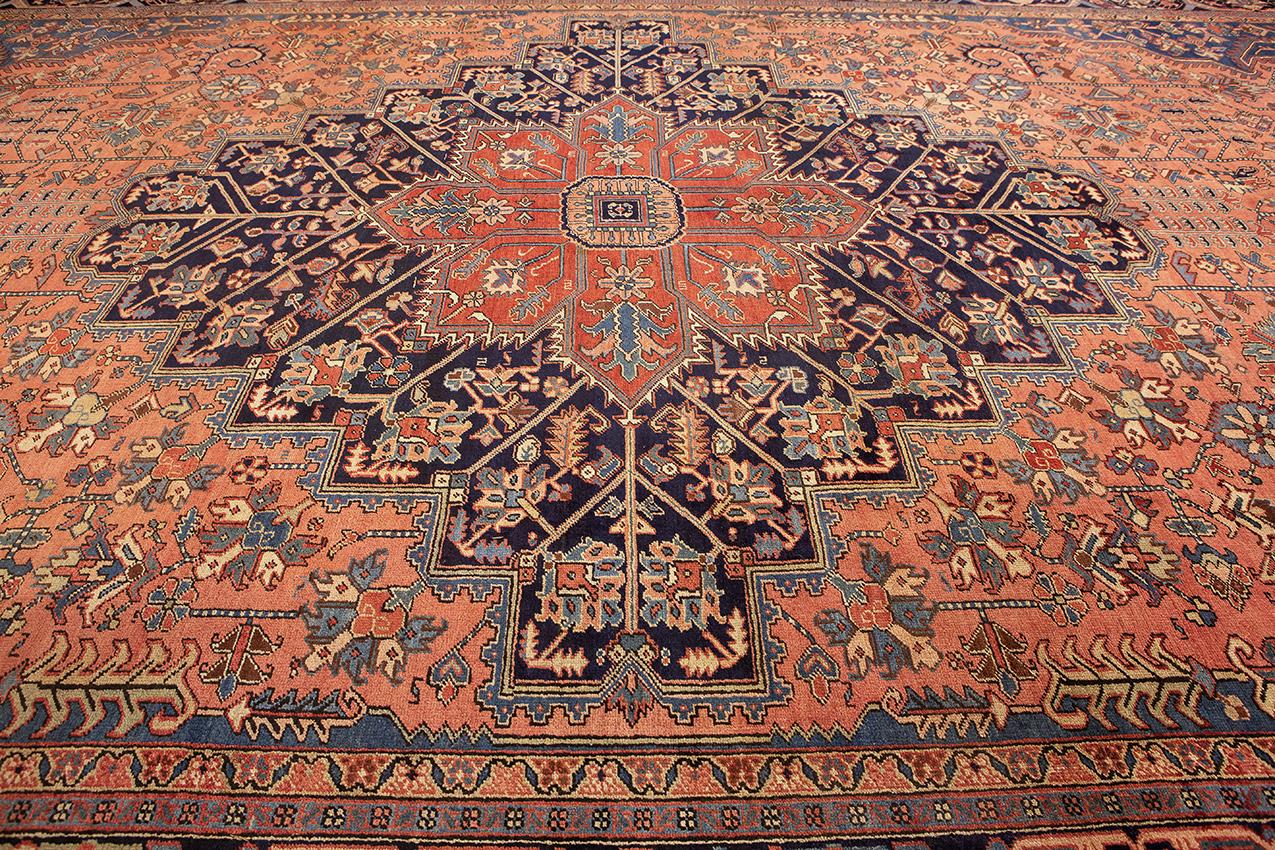 This is a true masterpiece antique large Heriz rug, a testament to the exquisite craftsmanship and artistic legacy of weaving. Measuring approximately 585cm x 350cm, this rug commands attention with its impressive size and beautiful design. The pale