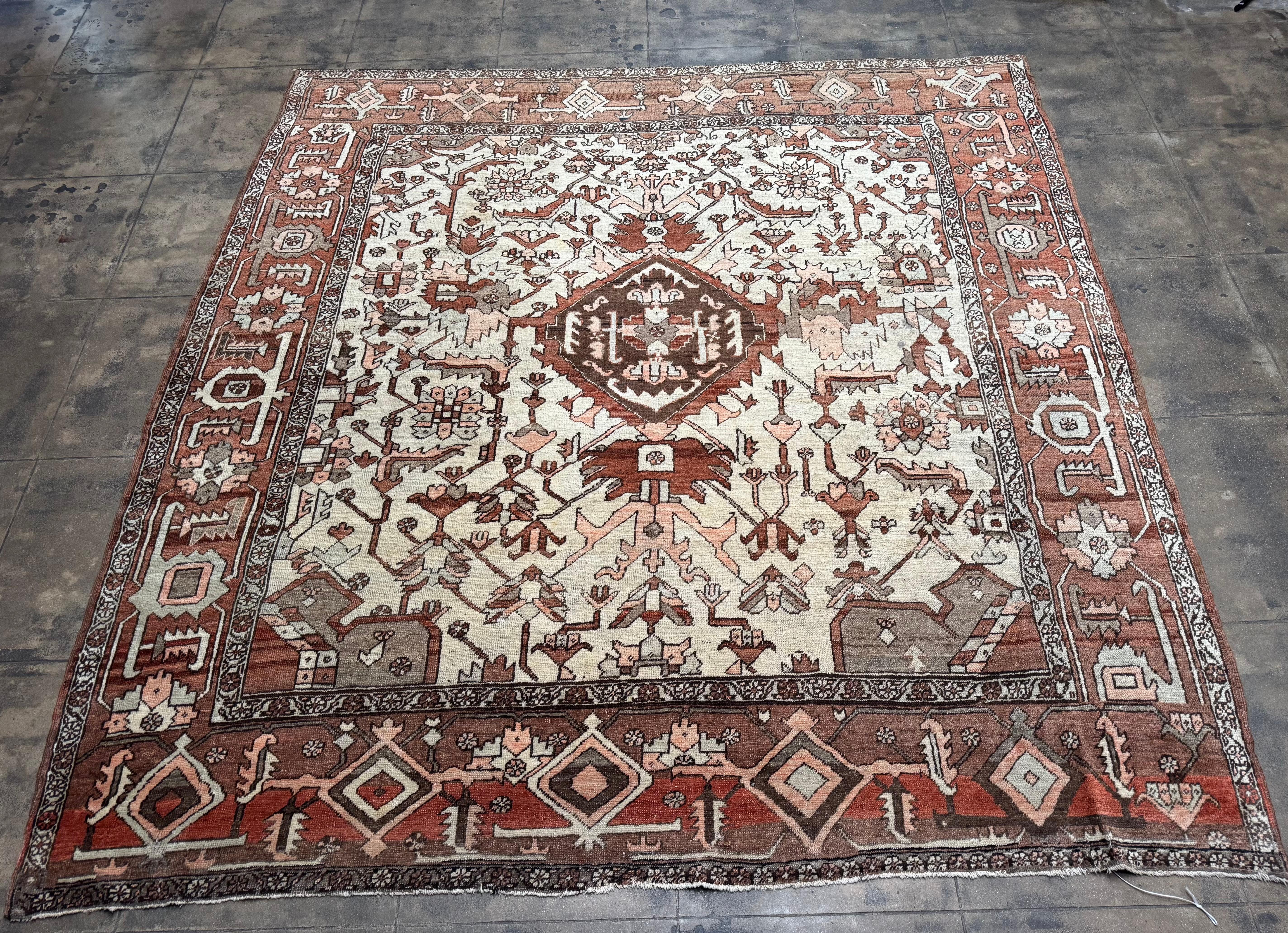 Un sorprendente tappeto Heriz antico, annodato a mano nel nord-ovest della Persia all'inizio del XX secolo. Questo pezzo, che misura circa 1 metro e 70 x 1 metro e 70, presenta gli audaci motivi geometrici e l'arte tribale che definiscono la