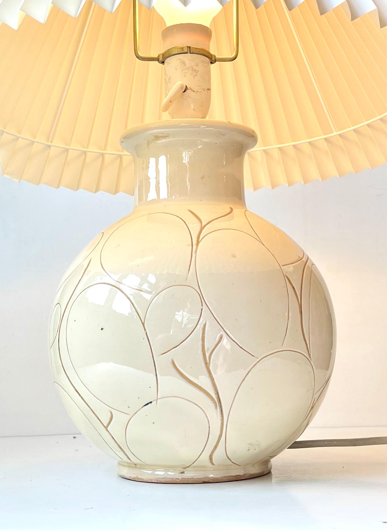 Large antique table lamp from the studio of Herman August Kähler. Monochrome cream pastel glaze with organic decor/incisions. Executed in Denmark circa 1920 and hugely inspired by the Art Nouveau movement. Signed HAK, Denmark and number 766. It