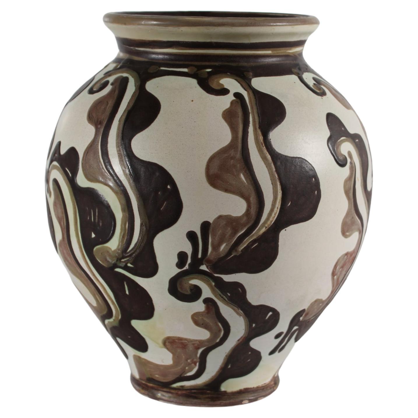 Danish ceramic handmade vase by Herman A. Kähler.
The vase has a matte sand colored basecoat with abstract hand-decorated pattern inspired by aquatic plants  in brown and light brown colours.
The decoration is most likely by the painter Elisabeth