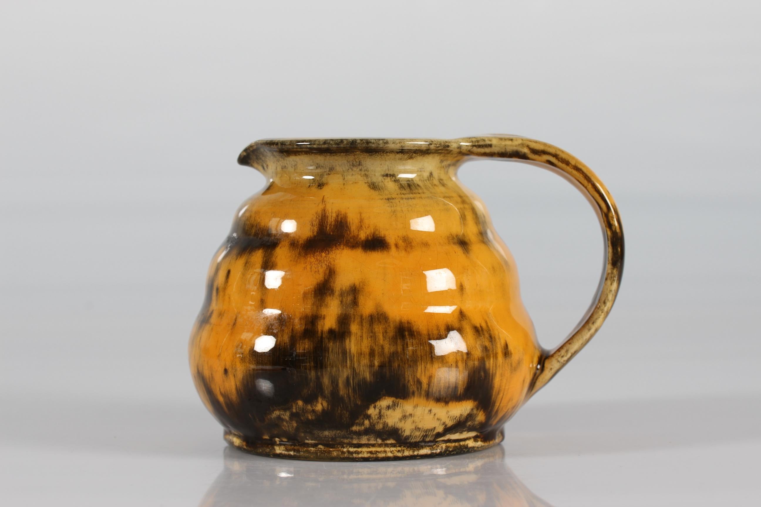Art Deco ceramic jug or pitcher designed by Nils Kähler and made by Herman A. Kählers ceramic workshop in the 1930s.
The jug is decorated with glossy yellow speckled uranium glaze and has the signature HAK + Denmark

Measures: 
Height 13,5