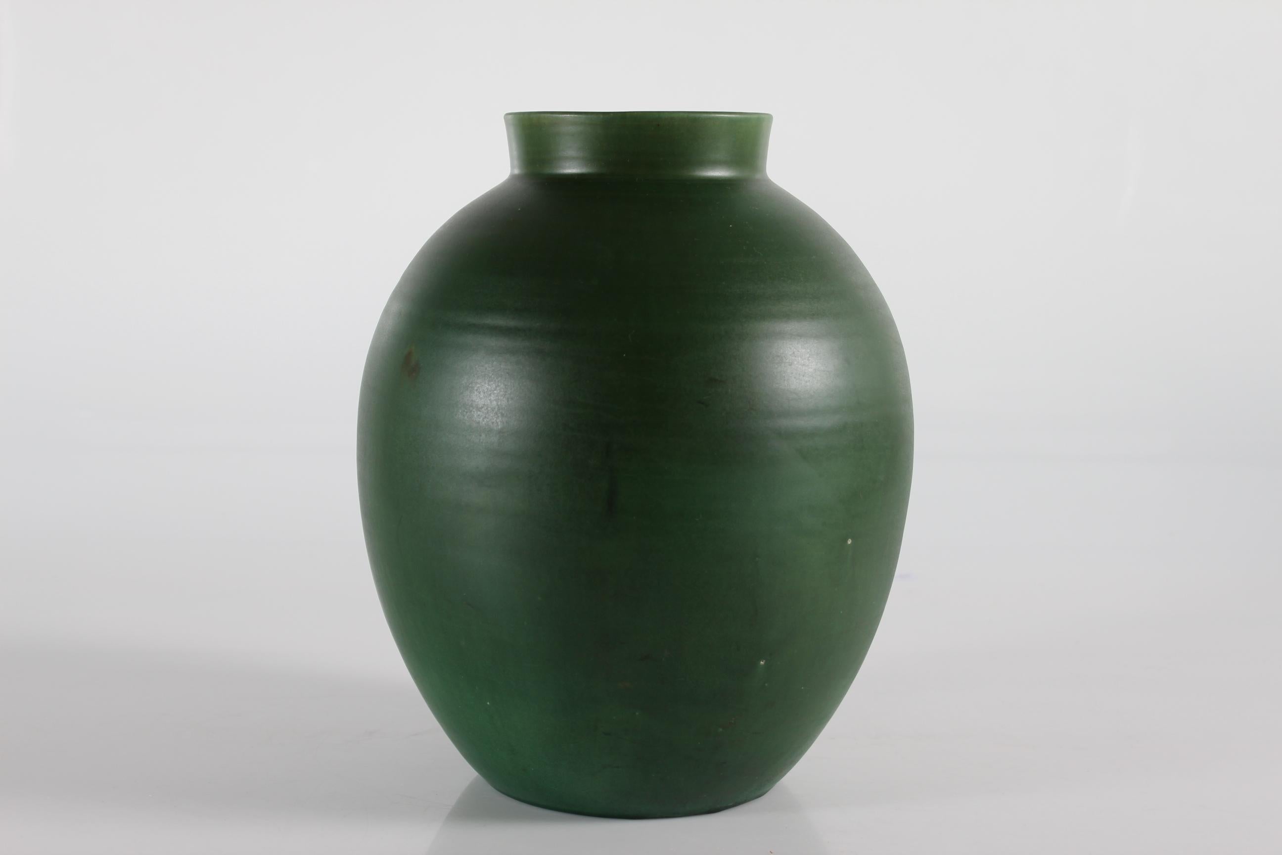 Large art deco vase by Nils Kähler made at Herman A. Kähler ceramic workshop in Nestved in Danmark circa 1930
The vase is handmade of ceramic and decorated with a delicate matte green glaze with few elements of white.


 