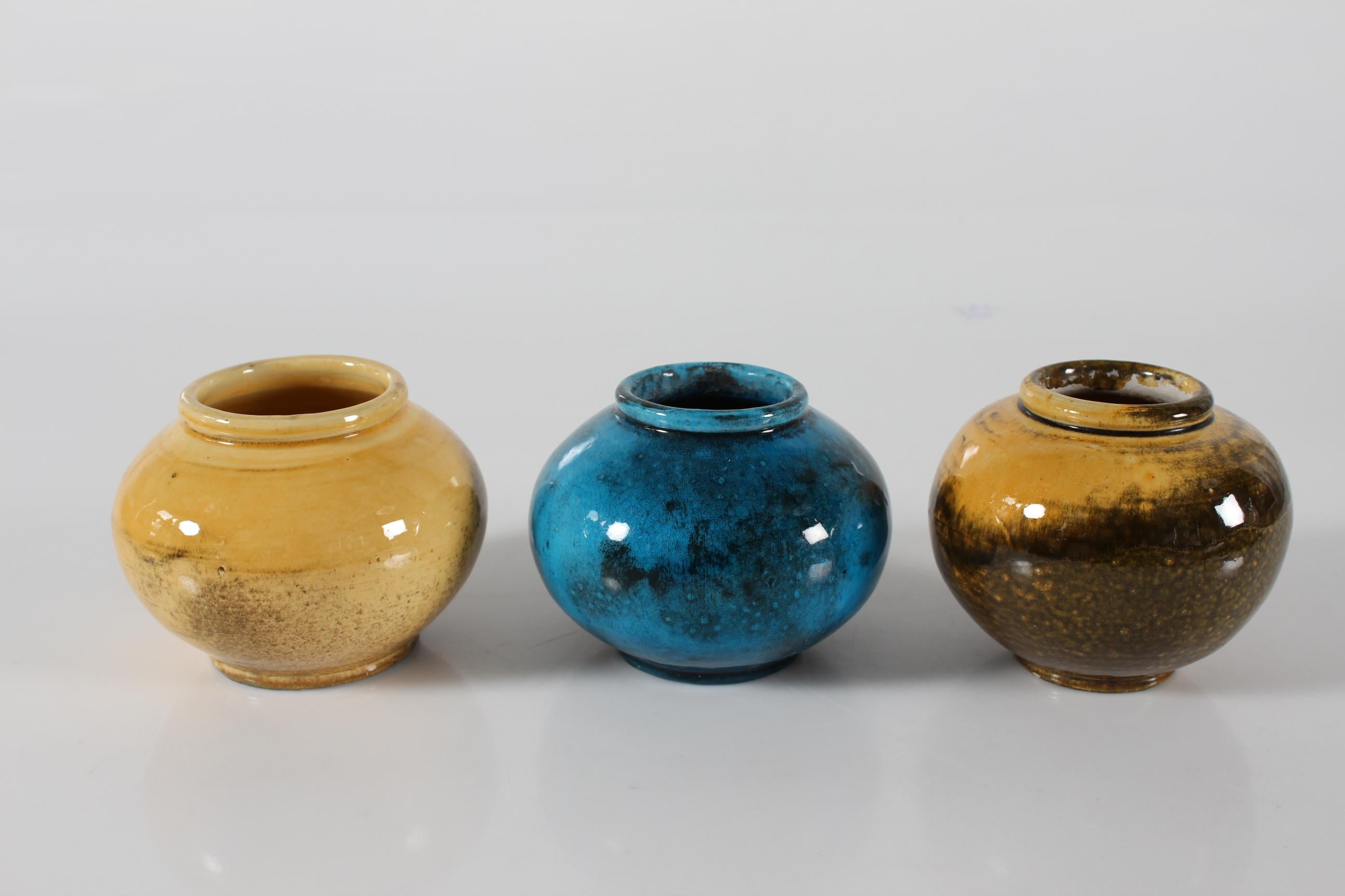 Set of 3 Art Deco spherical ceramic vases made by Herman A. Kähler in the 1930s.
The HAK vases are almost identical and decoratd with uranium glaze.
This glossy turquoise and ocher glaze with darker parts is developed by Nils Kähler and especially