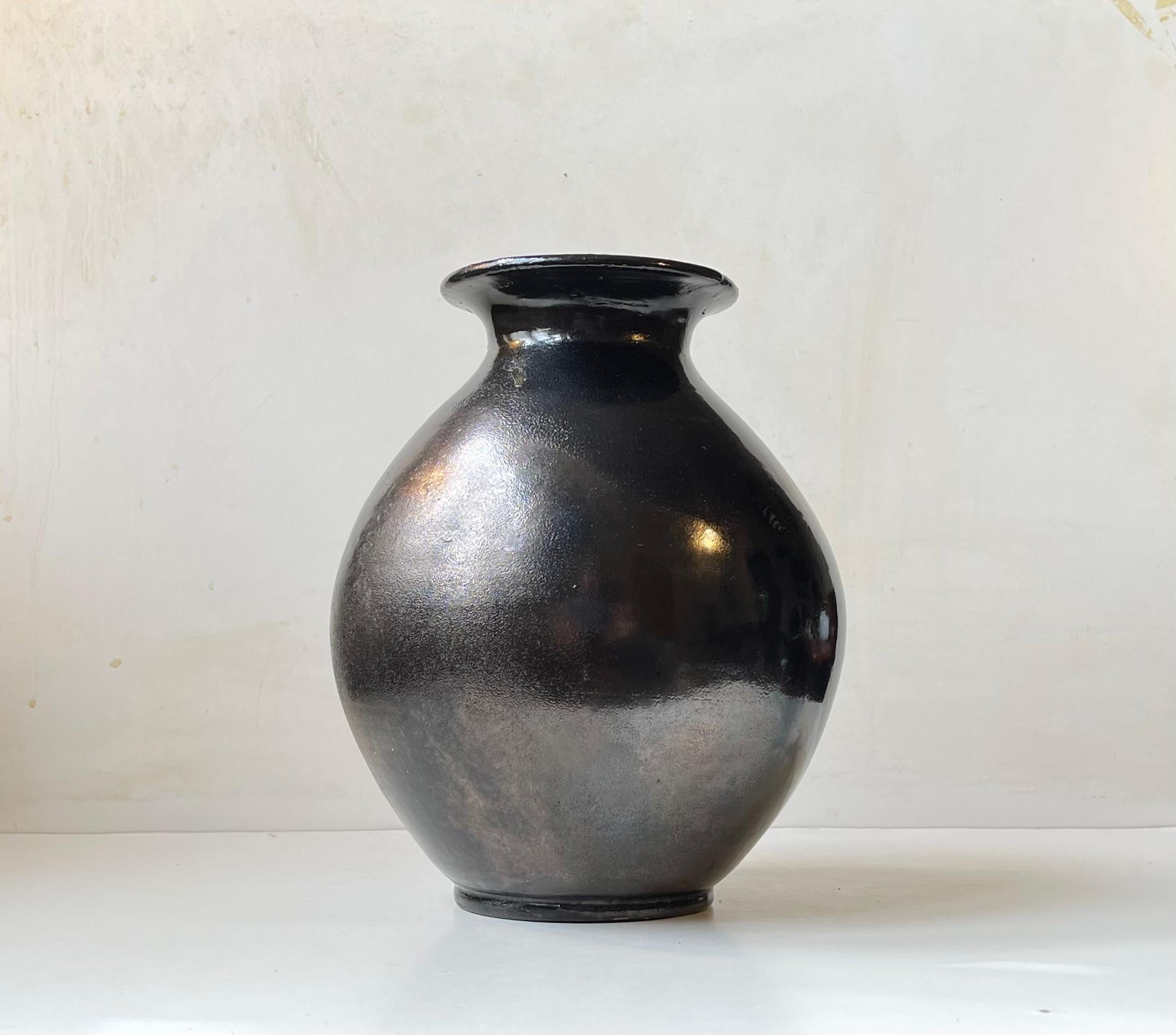Piece unique large vase or floor vase from the workshop of Herman August Kähler. It displays a rare satin black glaze with slate mirror-like effects. It was made circa 1920-25 and has a distinct dar yet shiny texture. A very tactile piece antique