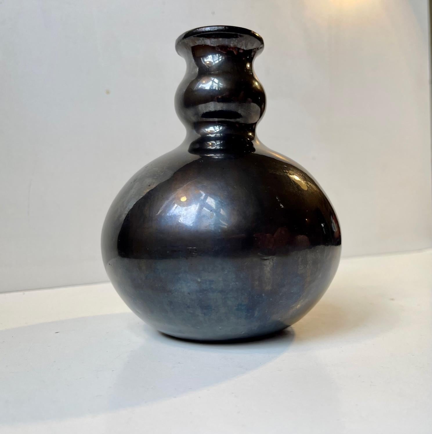 Piece unique from the workshop of Herman August Kähler. It displays a rare satin black glaze with slate mirror-like effects. It was made circa 1920-25 and has a distinct Art Deco stylings. Measurements: height is 16 cm, diameter: 12 cm.