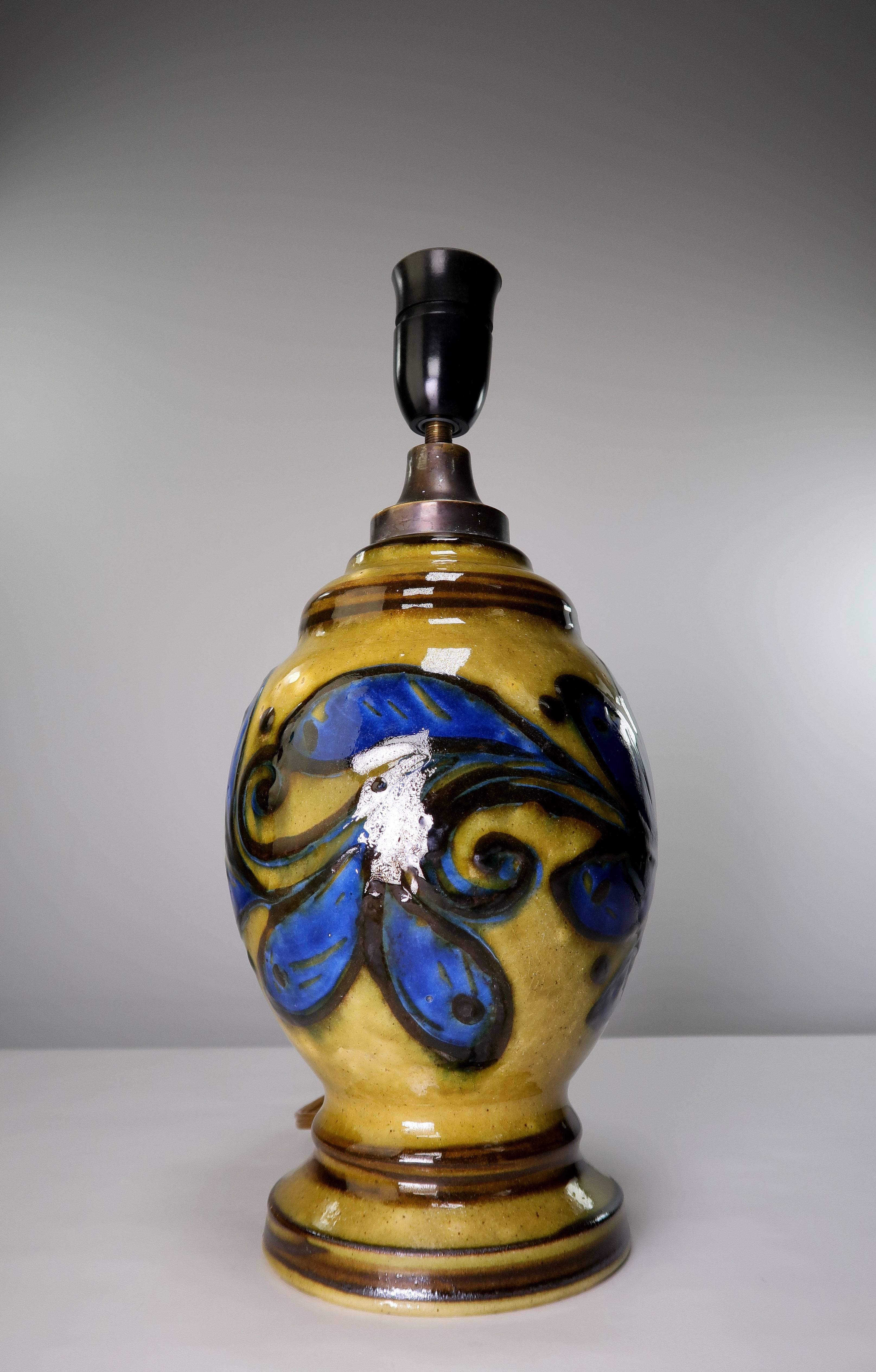 Unique, colorful Danish Art Deco bohemian style midcentury handmade and hand decorated table lamp by Kähler in the 1930s. An abstract floral motif in a clear cobalt blue upon mustard ochre glaze with dark brown lines to accentuate the shape around