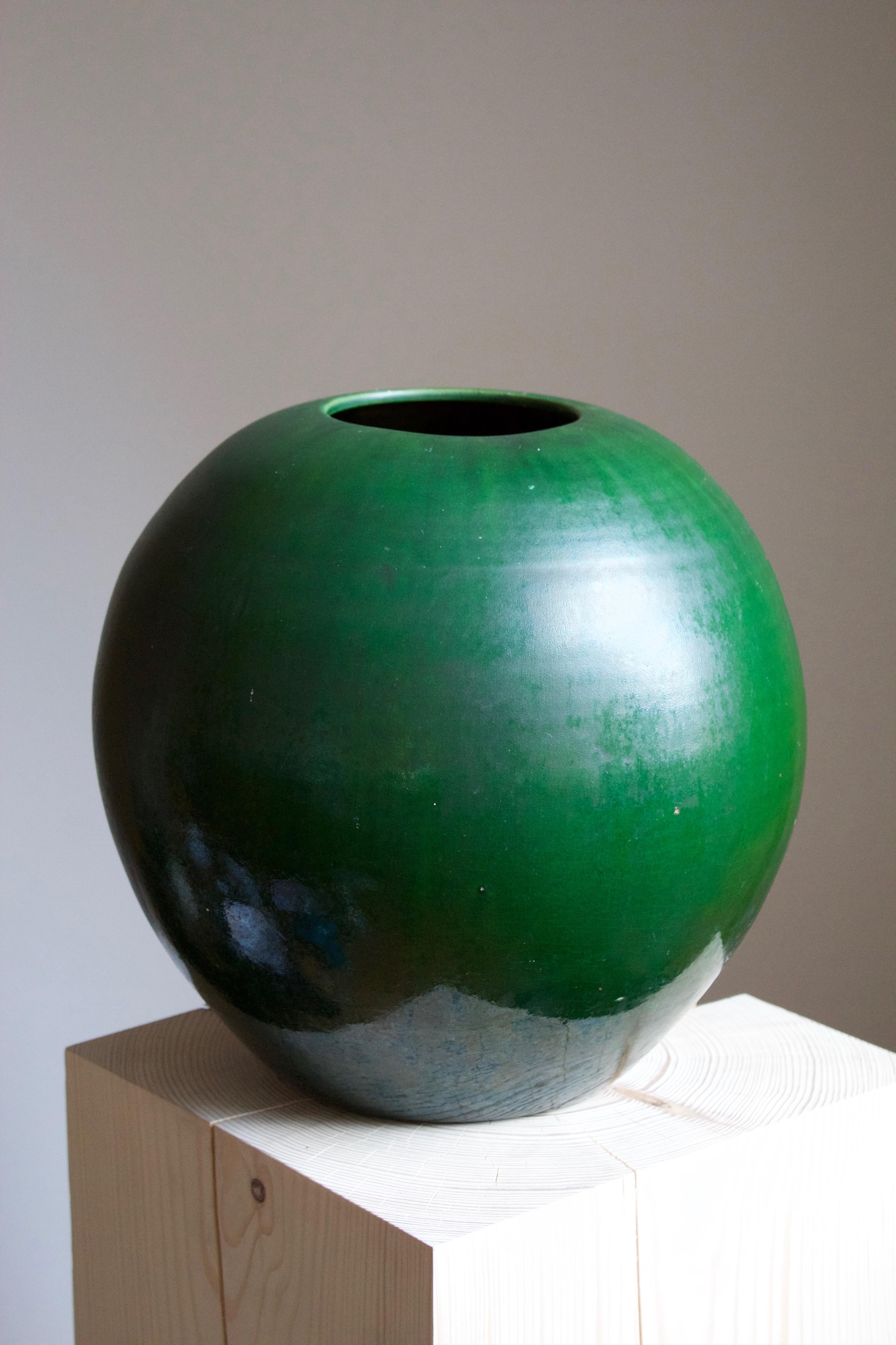 A very large vase. Designed and produced by Herman Kähler. Signed HAK. 

As is Kählers signature, the clay was sourced on the island of Bornholm. On this vase, a green glaze has been applied.

Kähler is an important ceramicist known for his