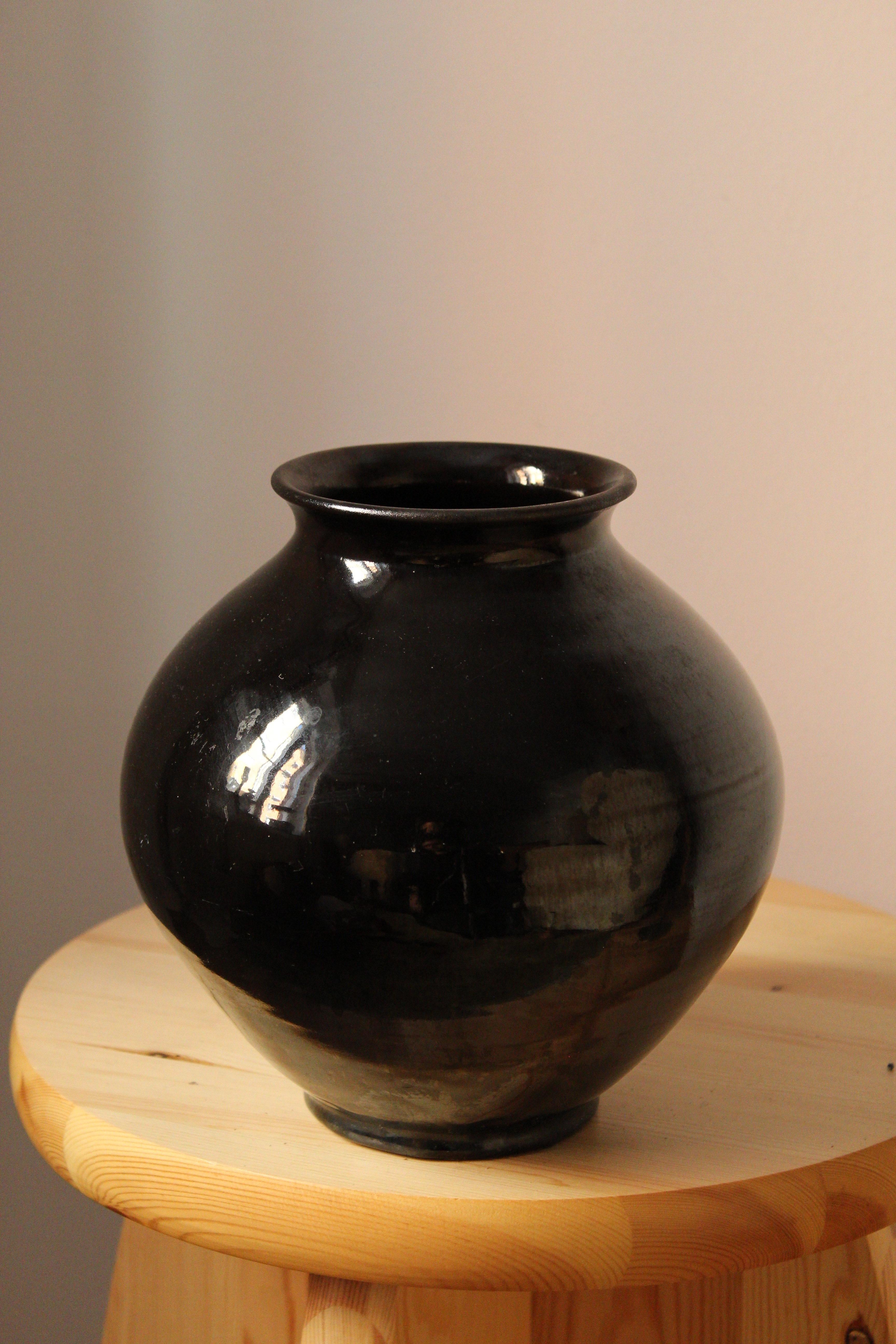A sizable vase. Designed and produced by Herman Kähler. Signed HAK. 

As is Kählers signature, the clay was sourced on the island of Bornholm. On this vase, a black glaze has been applied.

Kähler is an important ceramicist known for his modern