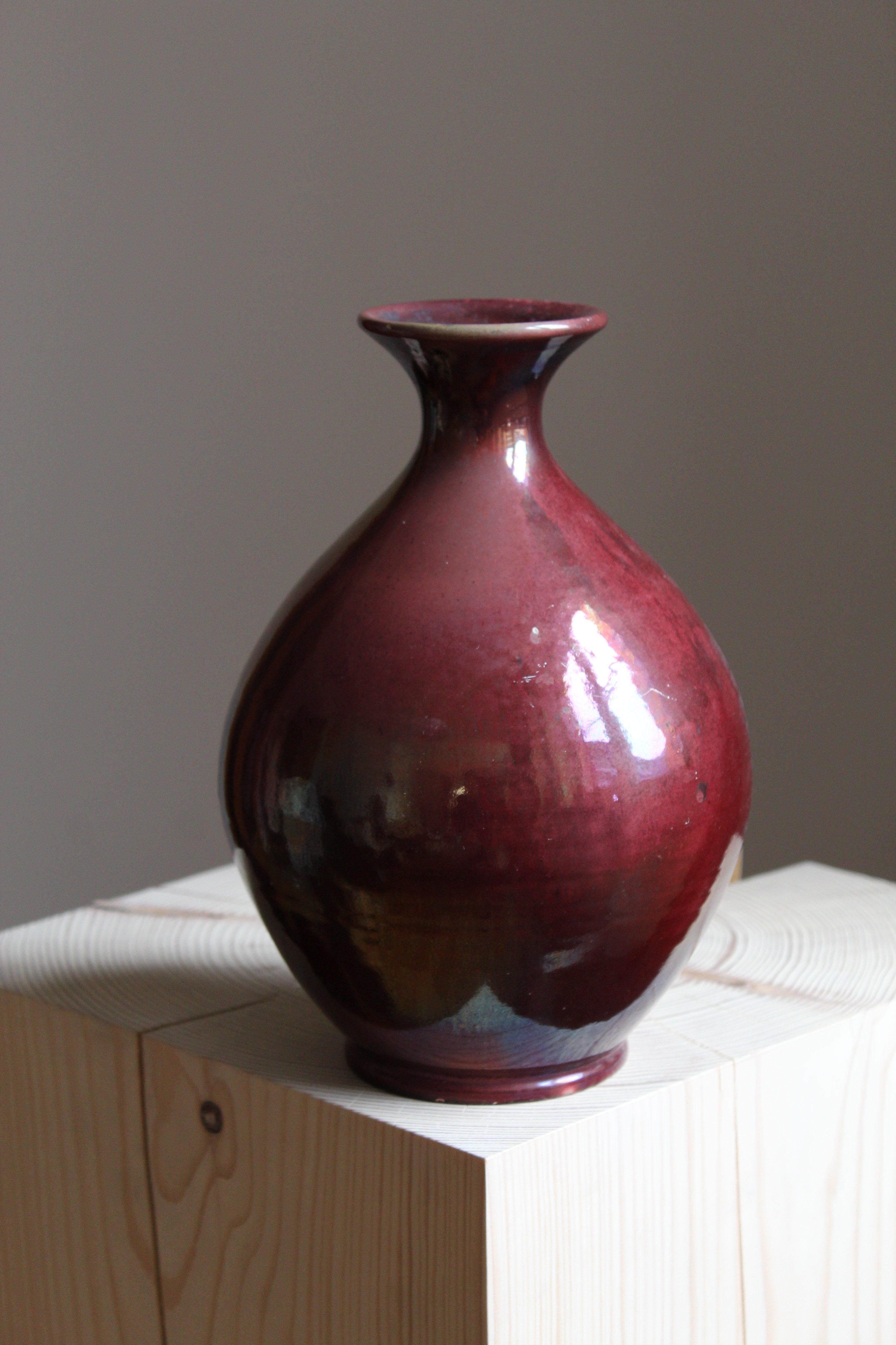 A sizable vase. Designed and produced by Herman Kähler. Signed HAK. 

As is Kählers signature, the clay was sourced on the island of Bornholm. On this vase, a highly complex and artistic oxblood glaze has been applied.

Kähler is an important