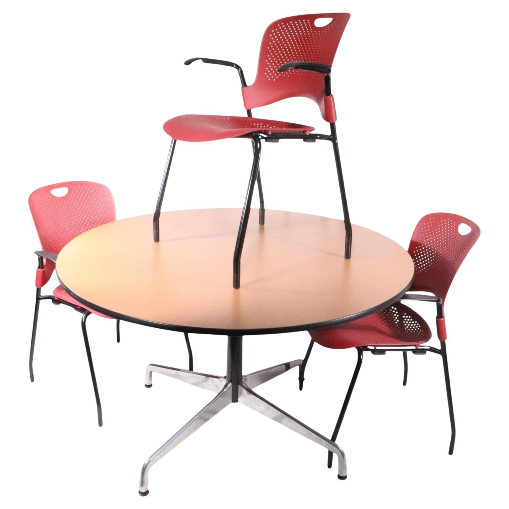 Unique opportunity to acquire a complete Herman Miller dining set, which includes four Caper Chairs, designed by Jeff Weber and dated 2006 , plus the iconic Eames design dining table, with Universal style base. The set is in excellent, original