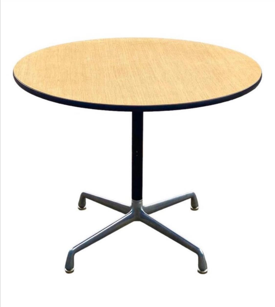 Beautiful and efficient dining table designed by Charles and Ray Eames and manufactured by Herman Miller. Model ET 102. Executed with polished aluminum base and wood grain laminate top. Table surface is extremely durable and moisture/stain