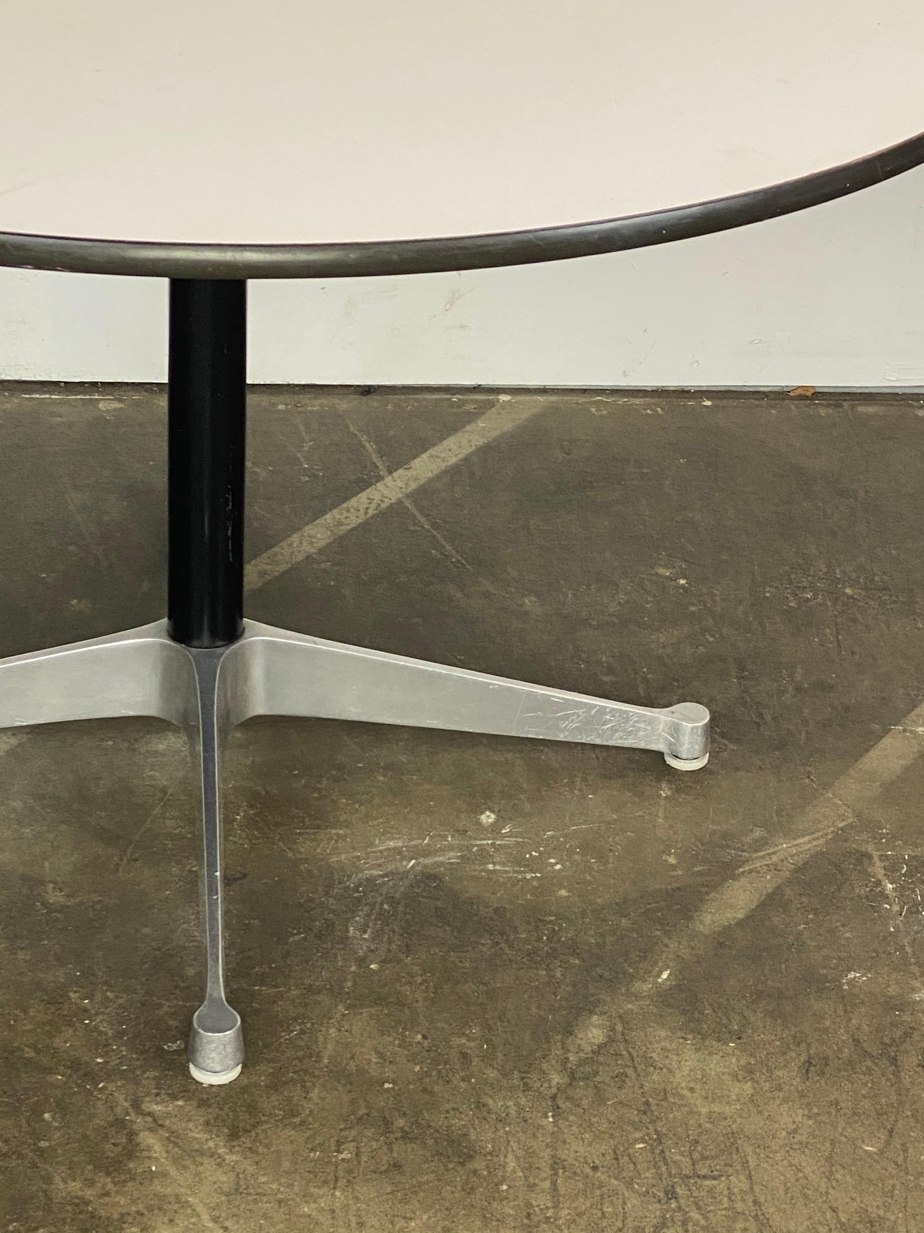 Table de salle à manger classique Herman Miller Eames. 48 pouces de diamètre. La taille permet d'accueillir jusqu'à 6 chaises. Plateau en stratifié blanc en bon état un groupe Eames supérieur en aluminium base de contrat.