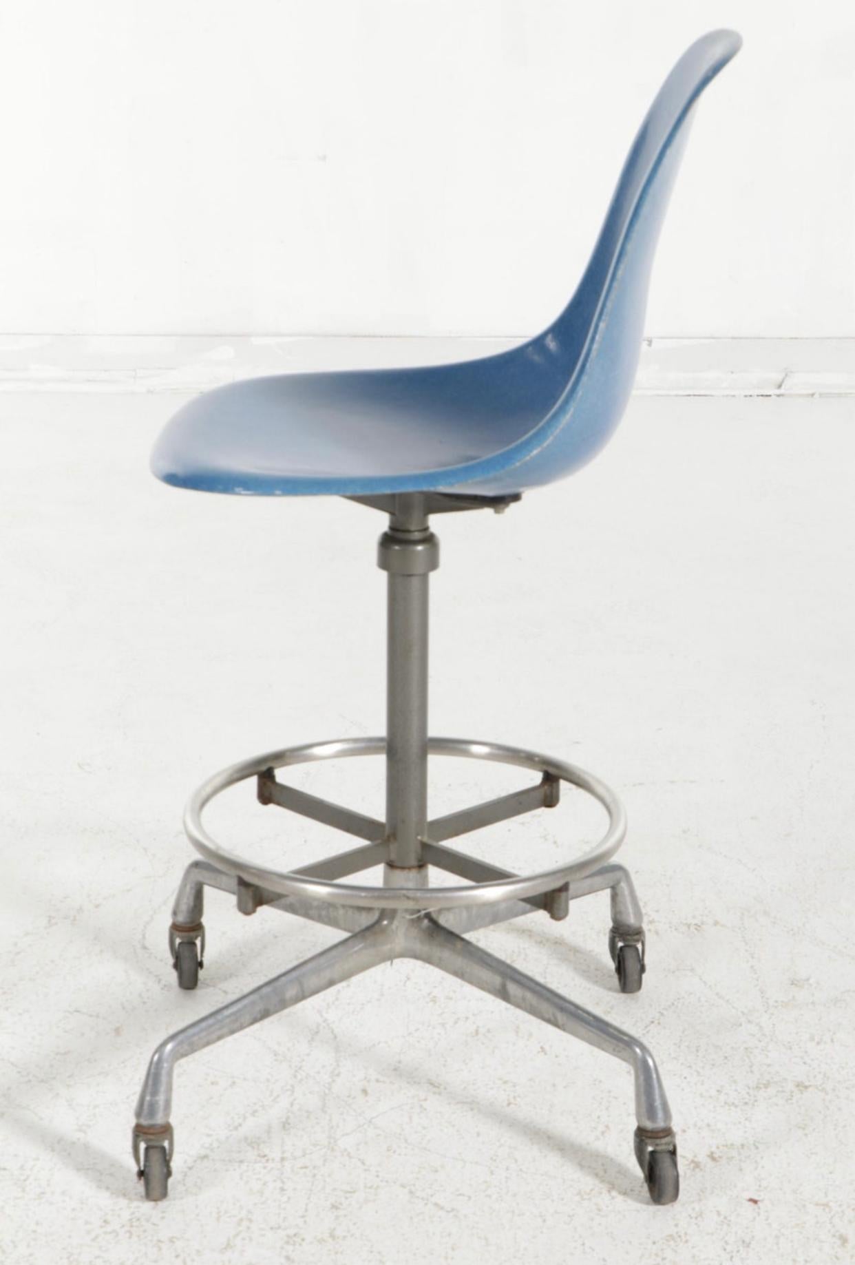 Gorgeous and rare Eames drafting stool produced by Herman Miller. Circa 1970s with cast aluminum base with wheels and adjustable height. Features rare color shell in Medium Blue. Gorgeous fiberglass texture and waterfall edge provide comfort for